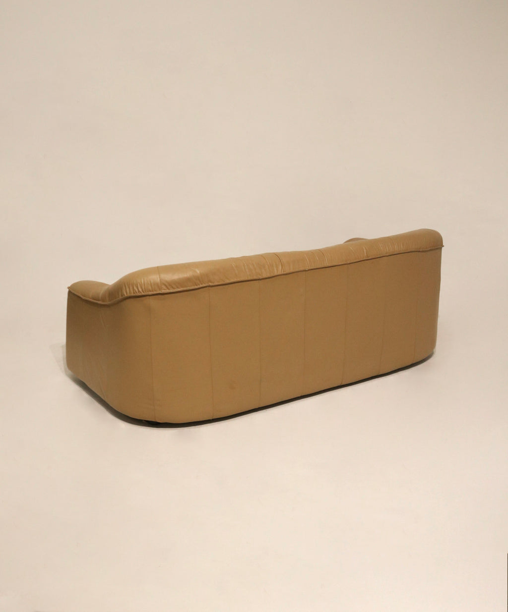 Detail of middle seat area with minor wear on beige brown leather surface