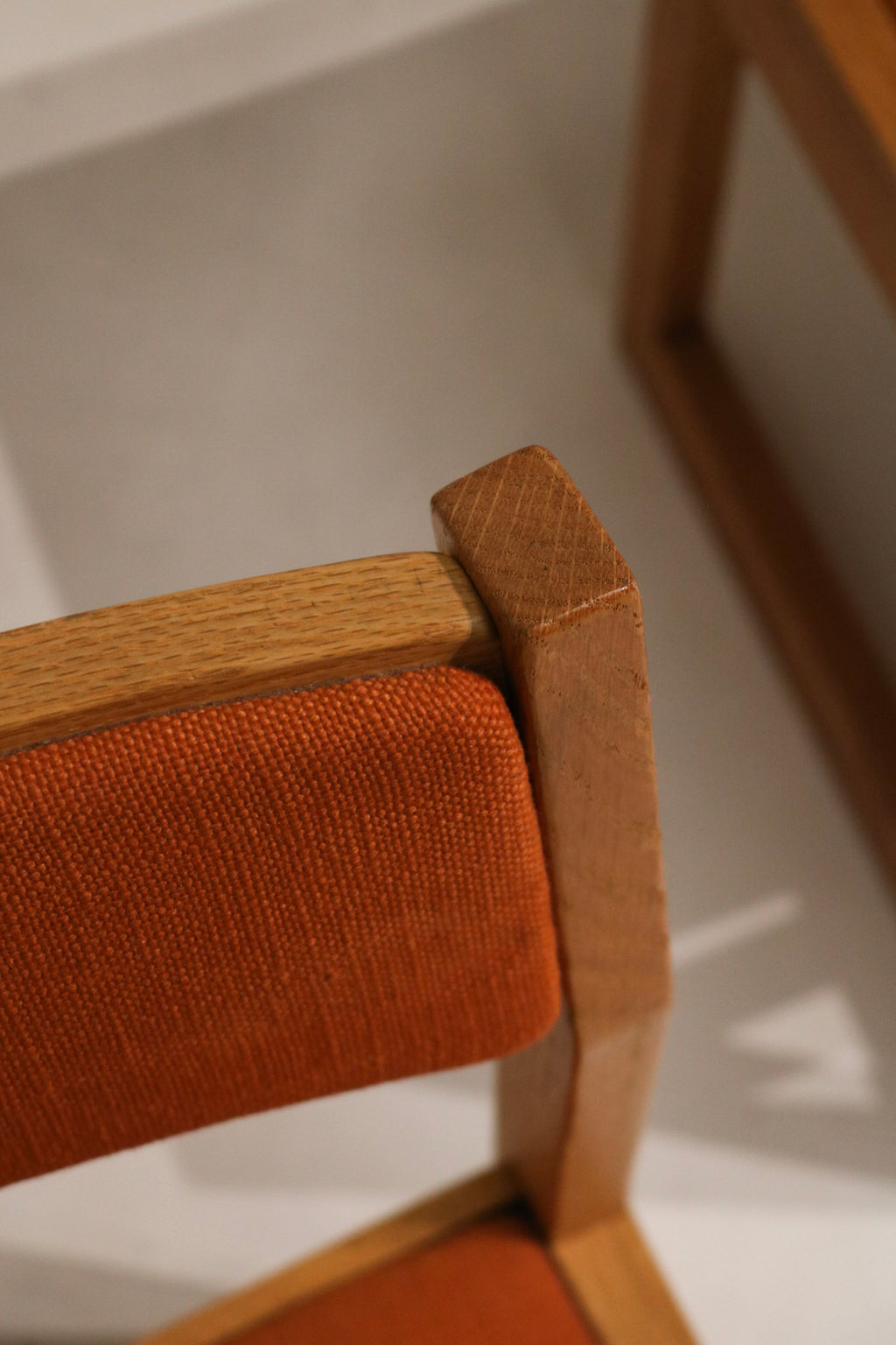 Stitching and seam detail on orange tweed upholstery edge showing tight stitching, minimal wear and well-preserved fabric texture.