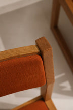 Stitching and seam detail on orange tweed upholstery edge showing tight stitching, minimal wear and well-preserved fabric texture.