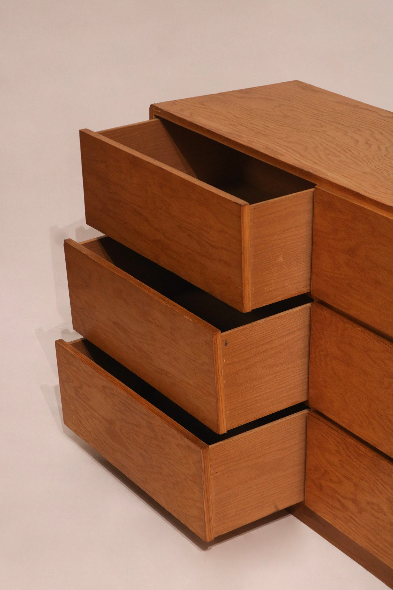 Close-up of chipped edge revealing inner particle board layer beneath oak finish