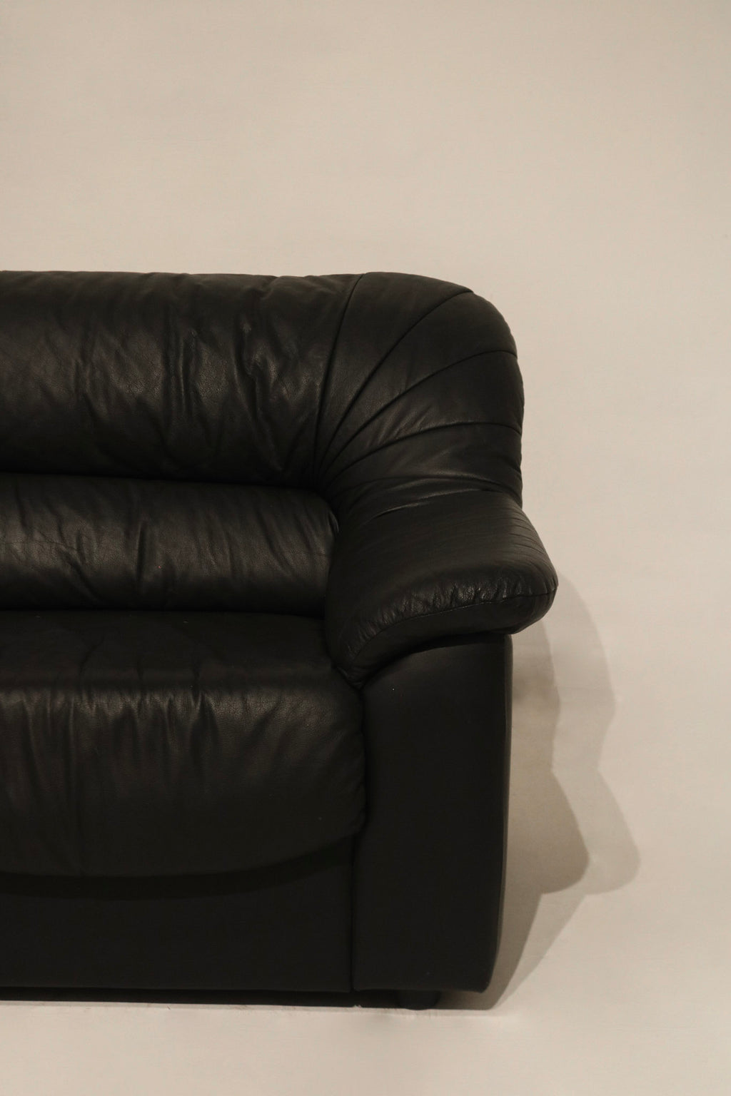 Texture detail of the leather on couch arm, highlighting vintage patina and softness