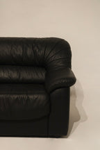 Texture detail of the leather on couch arm, highlighting vintage patina and softness