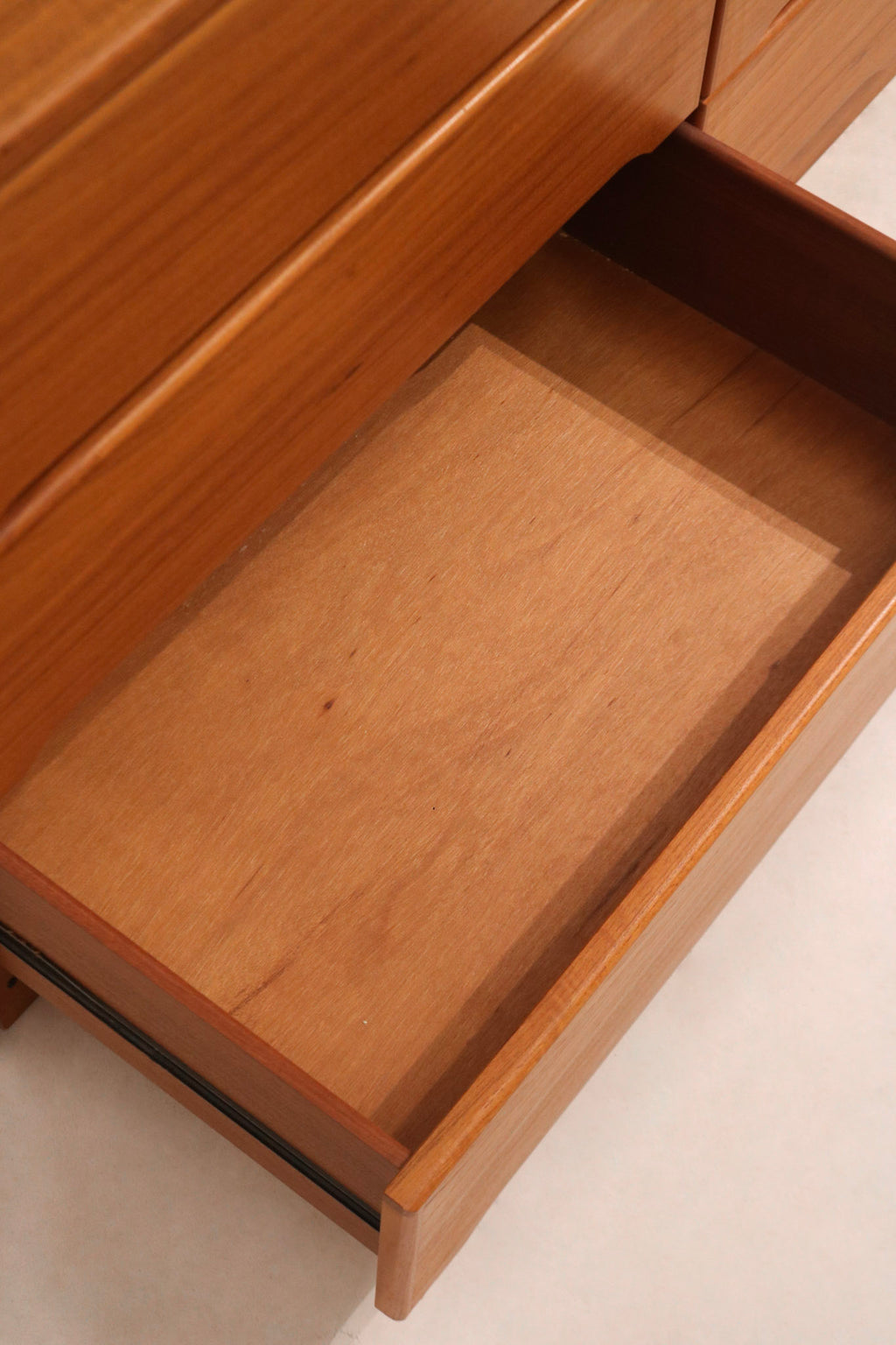 Natural light shot displaying rich tone of teak wood on MCM 9-drawer dresser