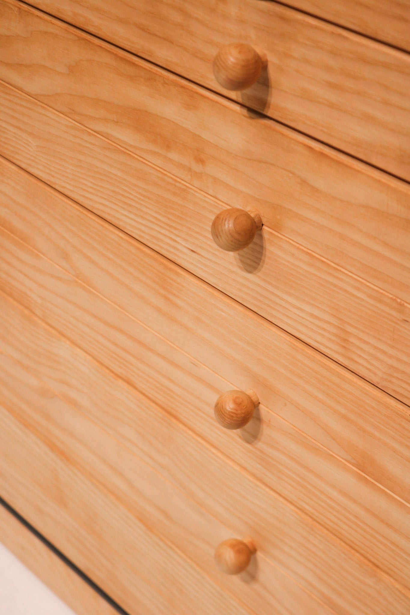 Close-up of dresser drawer handles and solid pine grain