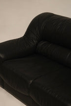 Close-up of sofa seat cushions, showing plush leather padding and high-quality craftsmanship