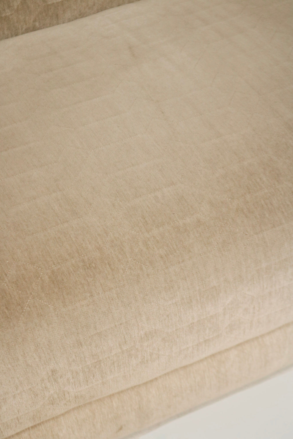Close-up of exposed base and leg attachment area, champagne velvet fabric wrapped frame and reinforced junction with secure hardware visible