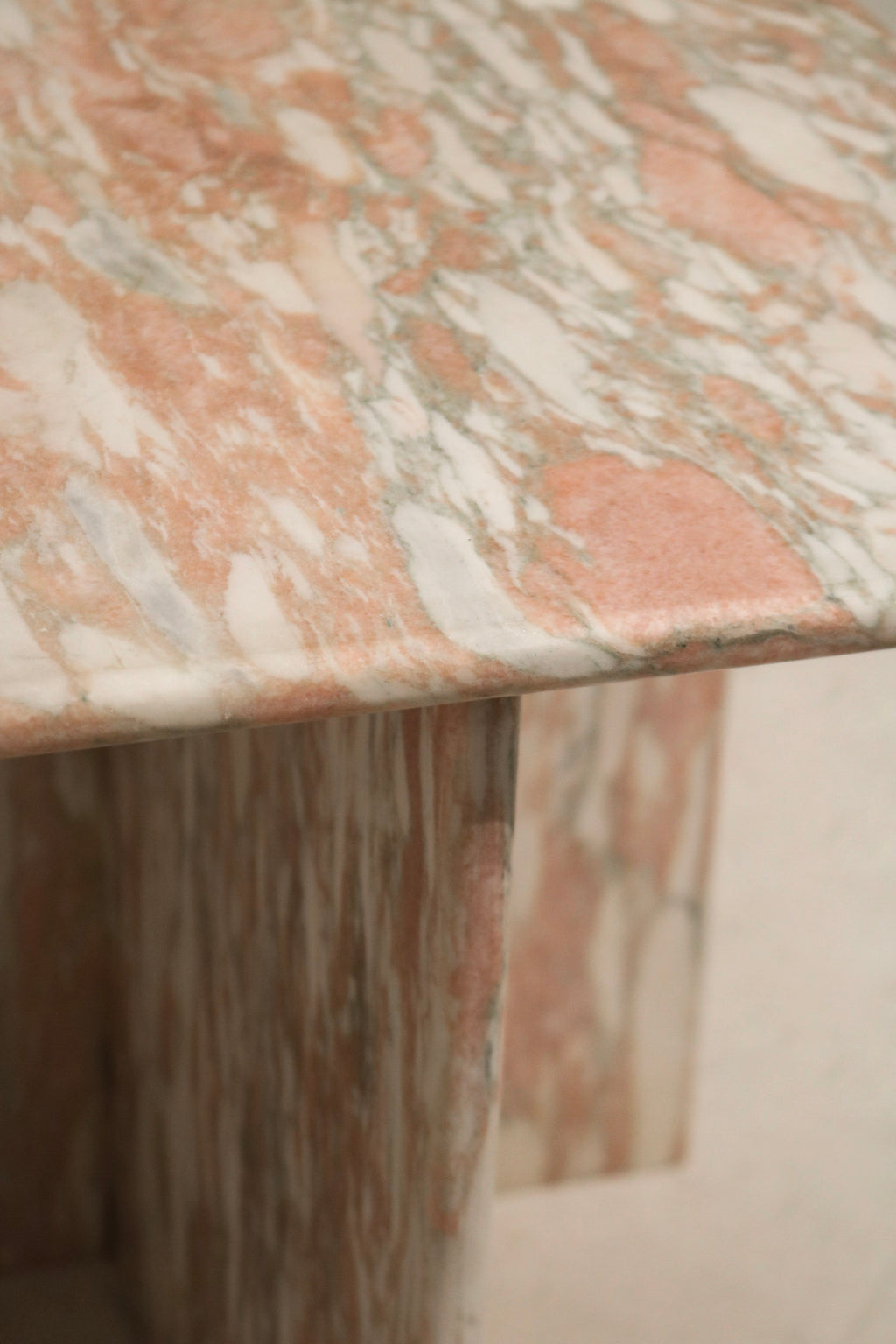 Underneath and junction detail of the marble table, seamless construction, solid stone build, no cracks or chips evident.