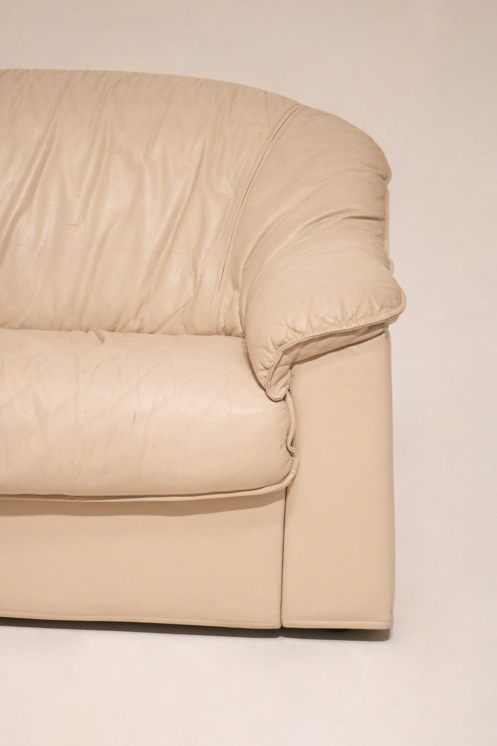 Close-up of corner section of beige leather Salotti Natuzzi sofa highlighting stitching details