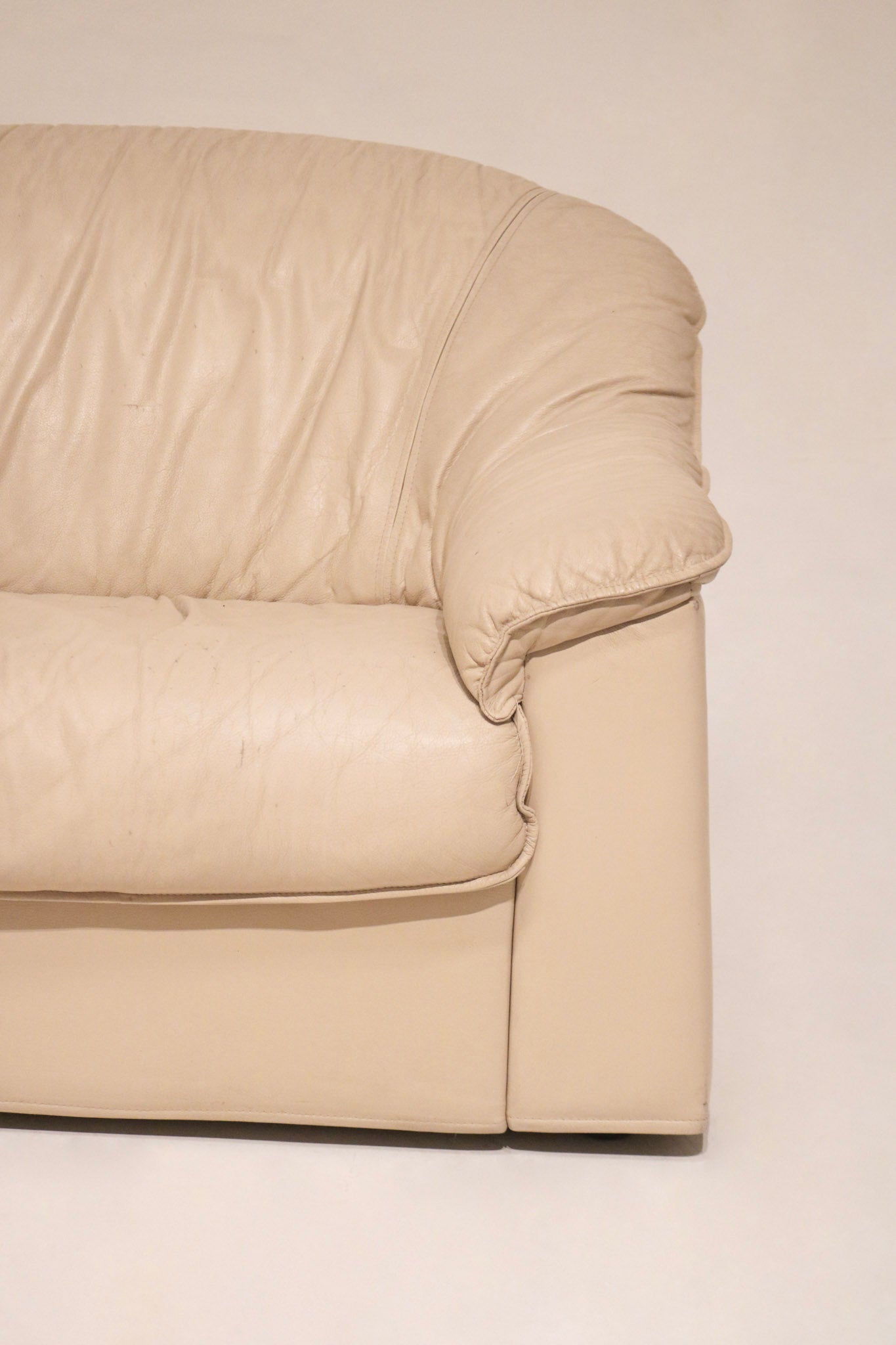 Close-up of corner section of beige leather Salotti Natuzzi sofa highlighting stitching details