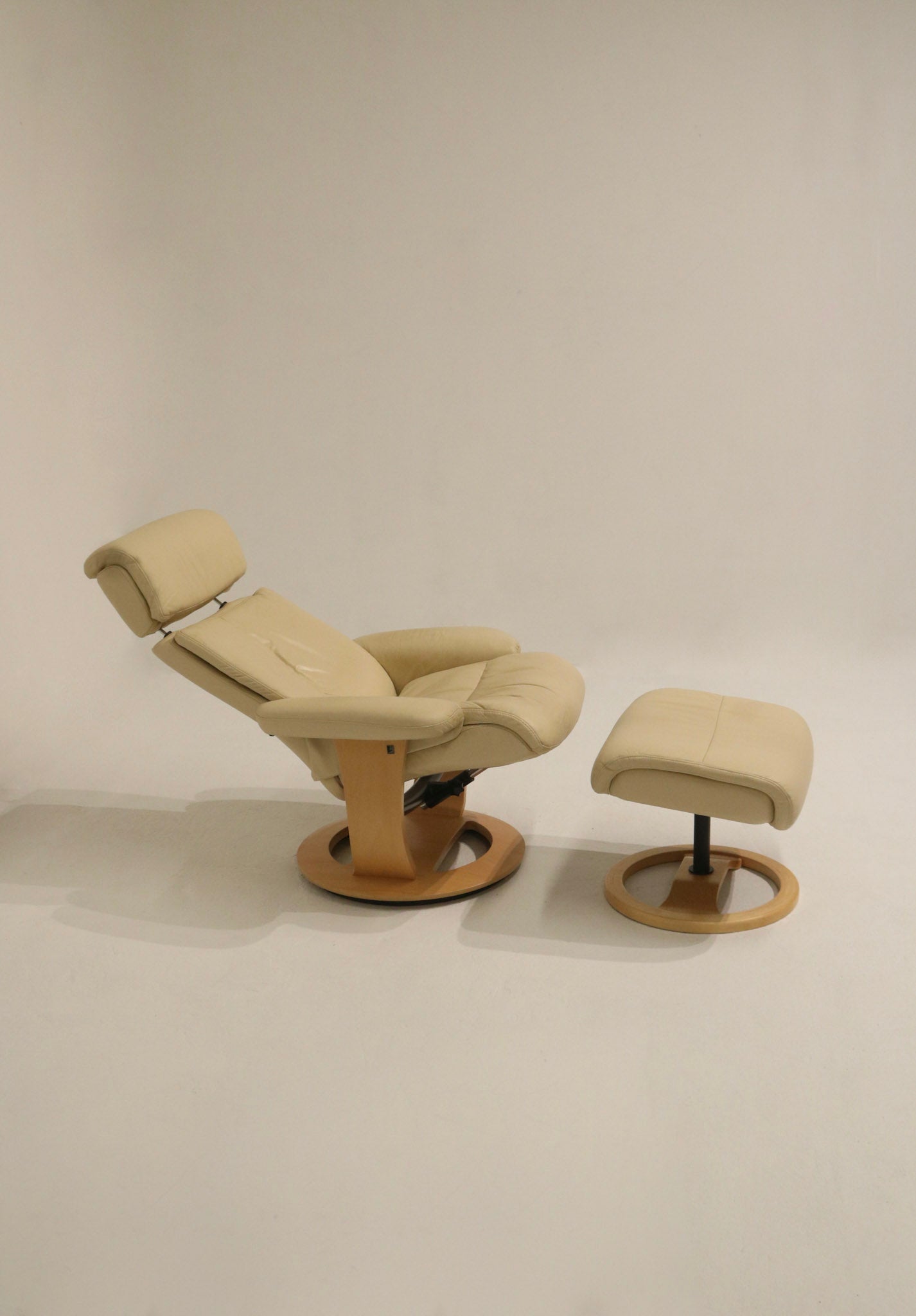 Lounge chair upholstered in cream-tone faux leather