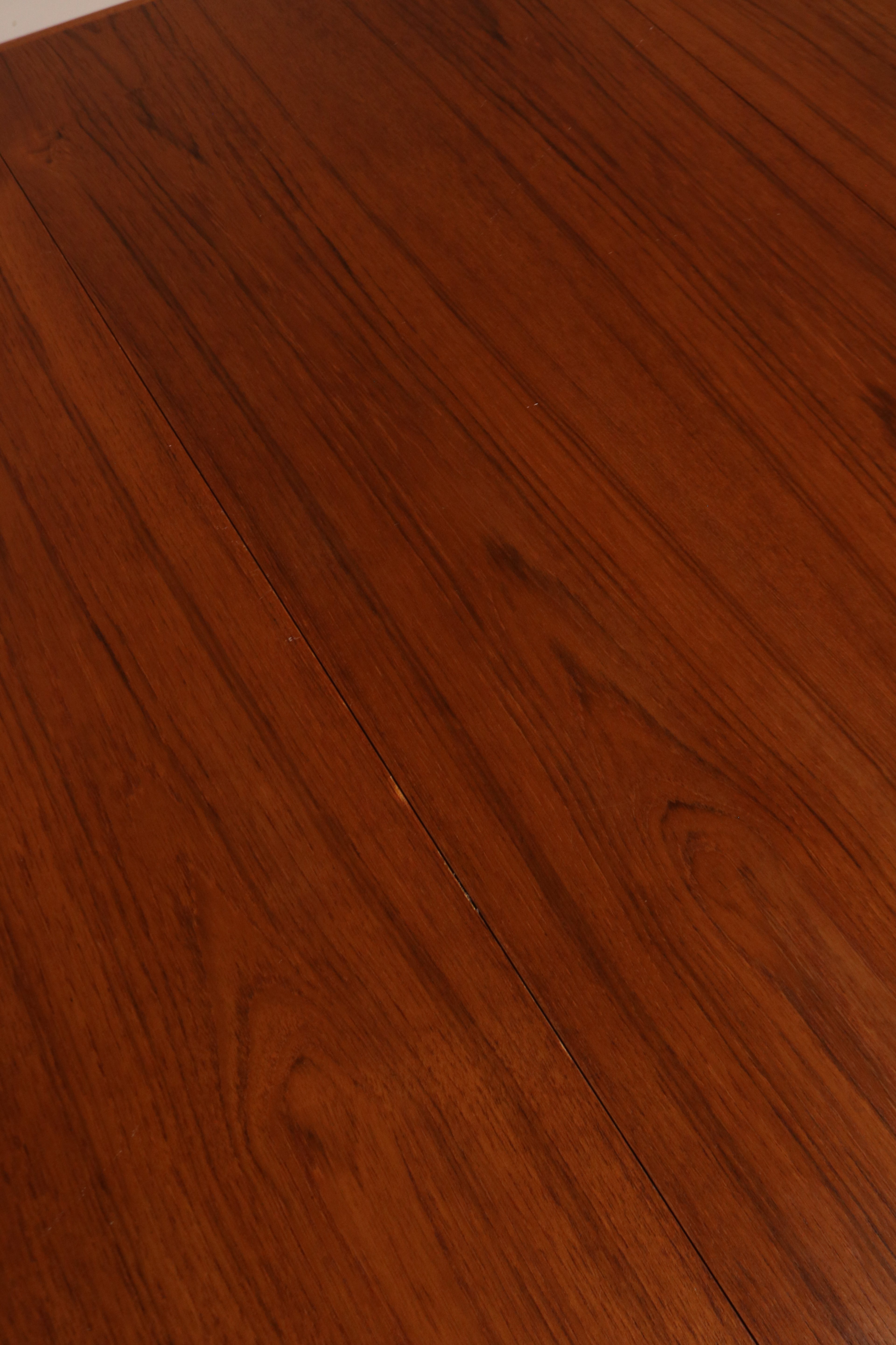 Angled view capturing expanded length of the table set for nine-seat arrangement