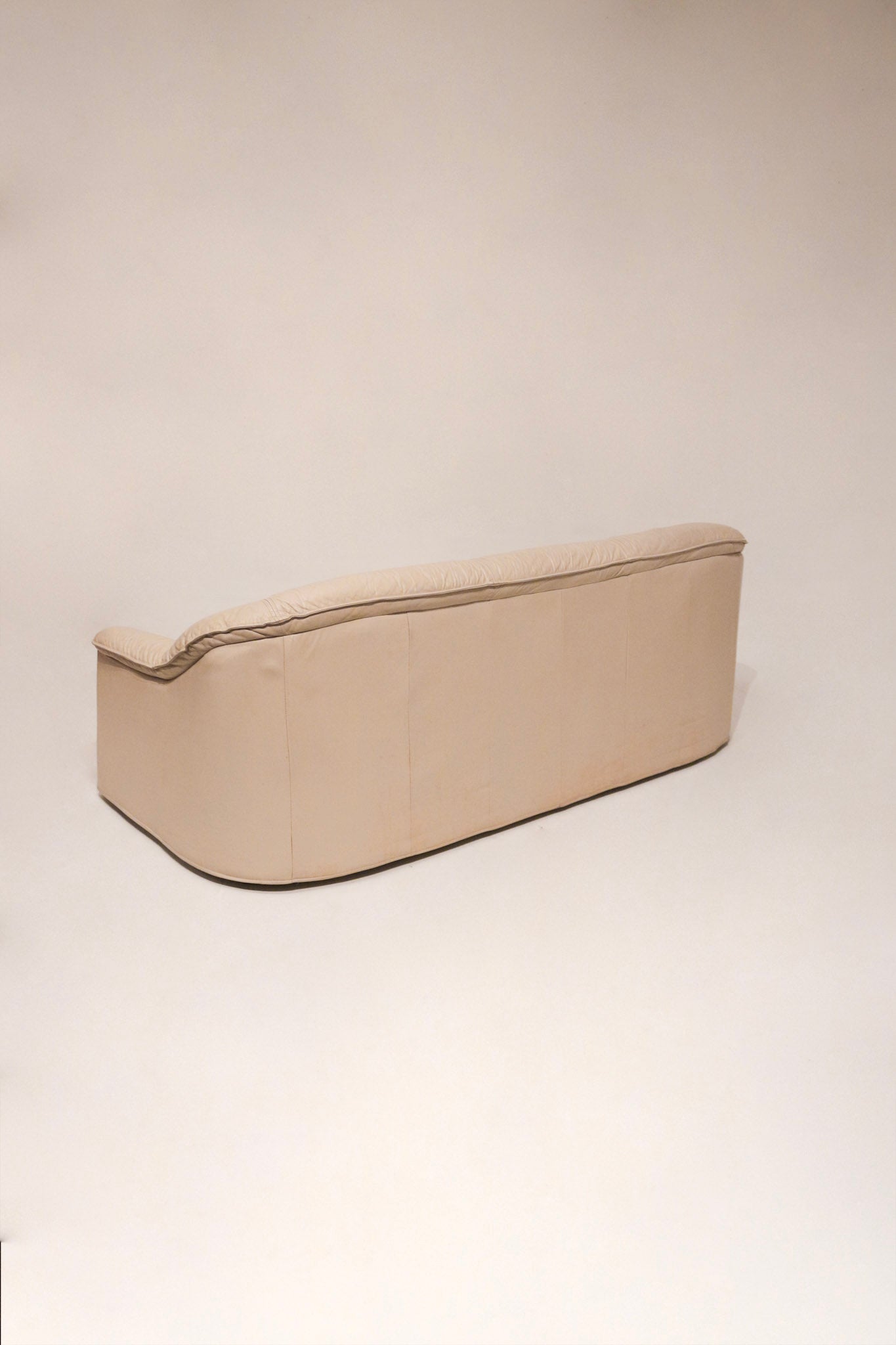 Top-down view of seat cushions on vintage Natuzzi leather sofa in beige color