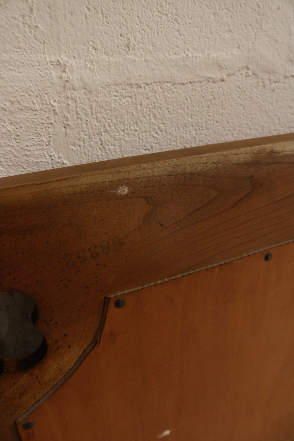 Close-up of solid oak wood grain and distressed finish showing small scratches, worn edges, and vintage patina on the frame.