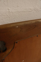 Close-up of solid oak wood grain and distressed finish showing small scratches, worn edges, and vintage patina on the frame.