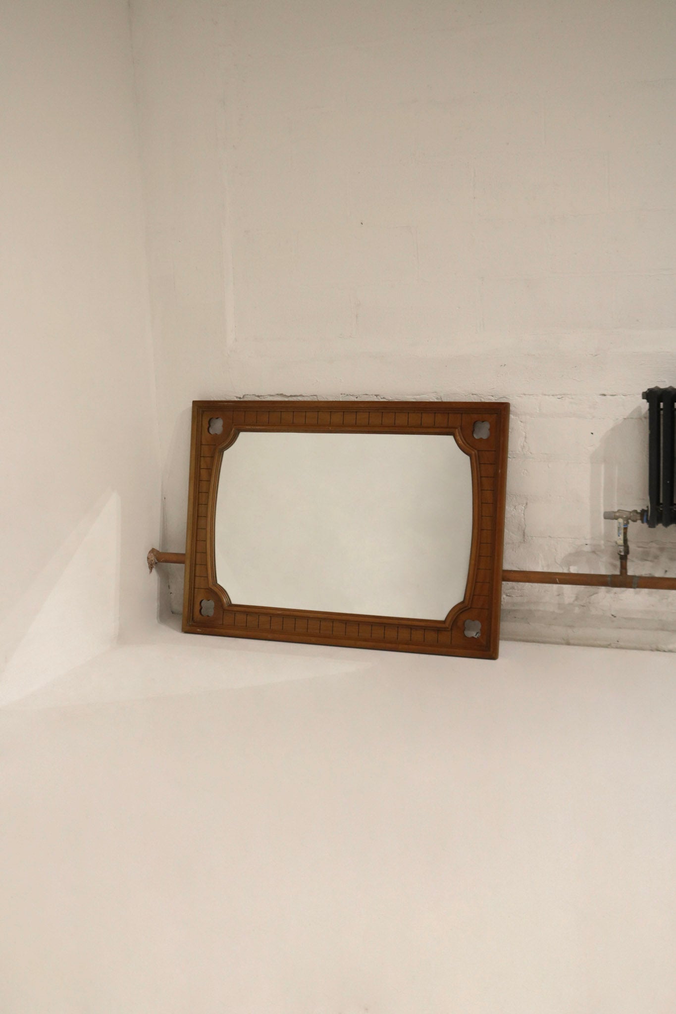 Metal hanging hardware on oak wood frame, vertical brackets shown; adaptable for horizontal display and secure wall mounting.