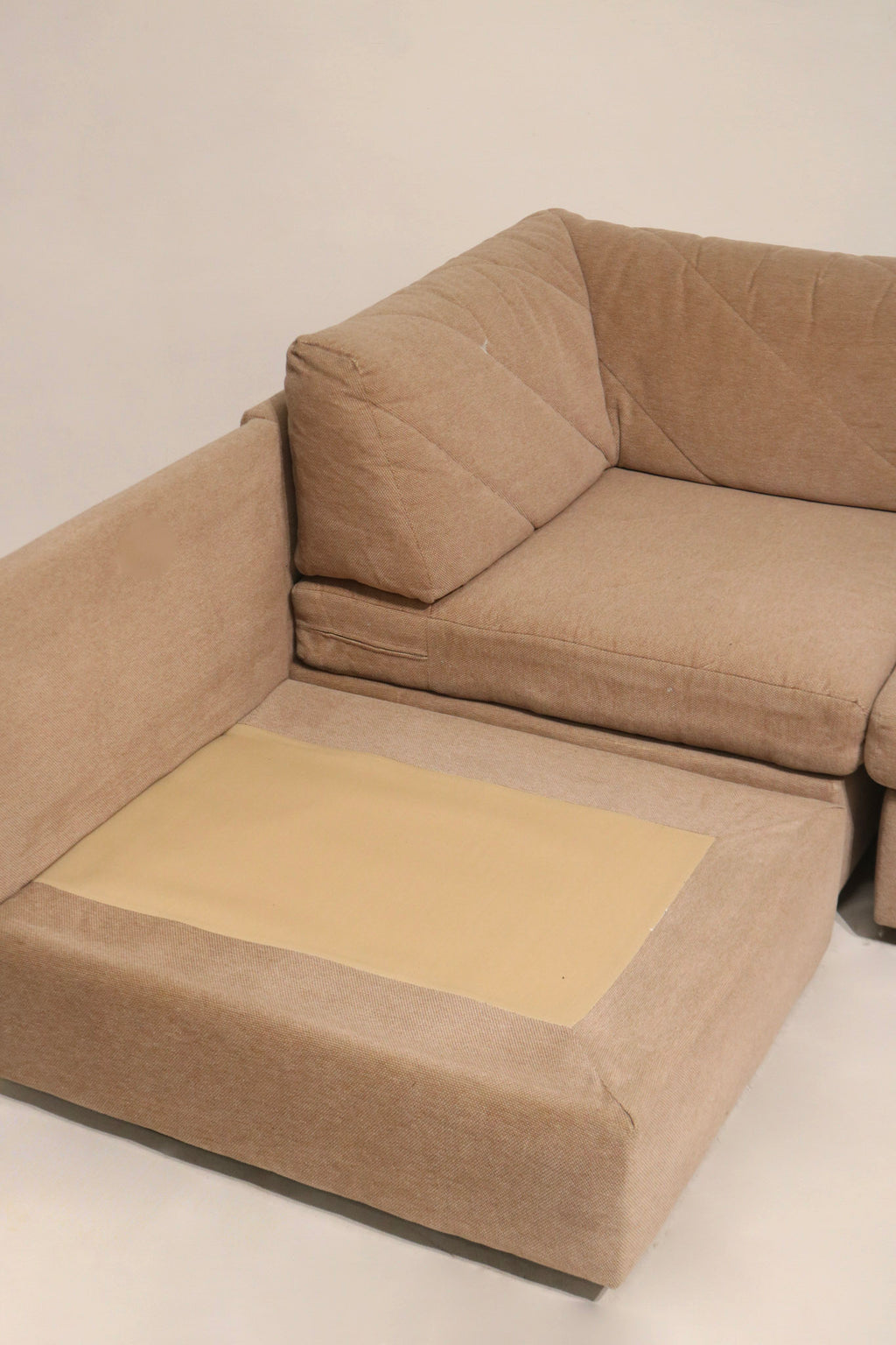 Zoom on upholstery hardware and corner bracket on Mcm fabric sofa demonstrating durable connections and midcentury modular assembly