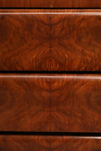 Close-up of burlwood grain texture on dresser top surface in warm natural wood tones