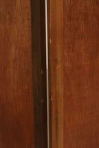 Detail of panel edge and hinge construction in pine wood, showing metal hardware, dovetail joints and hand-finished texture.
