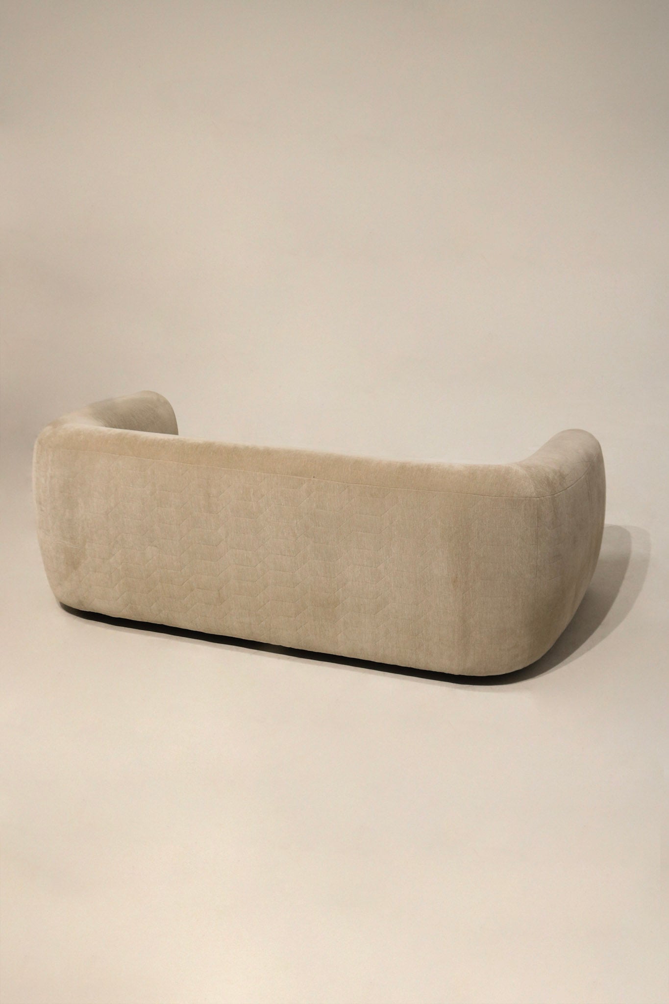 Close-up of champagne velvet fabric texture showing soft nap, subtle sheen and clean surface with minor wear, high-quality upholstery detail visible