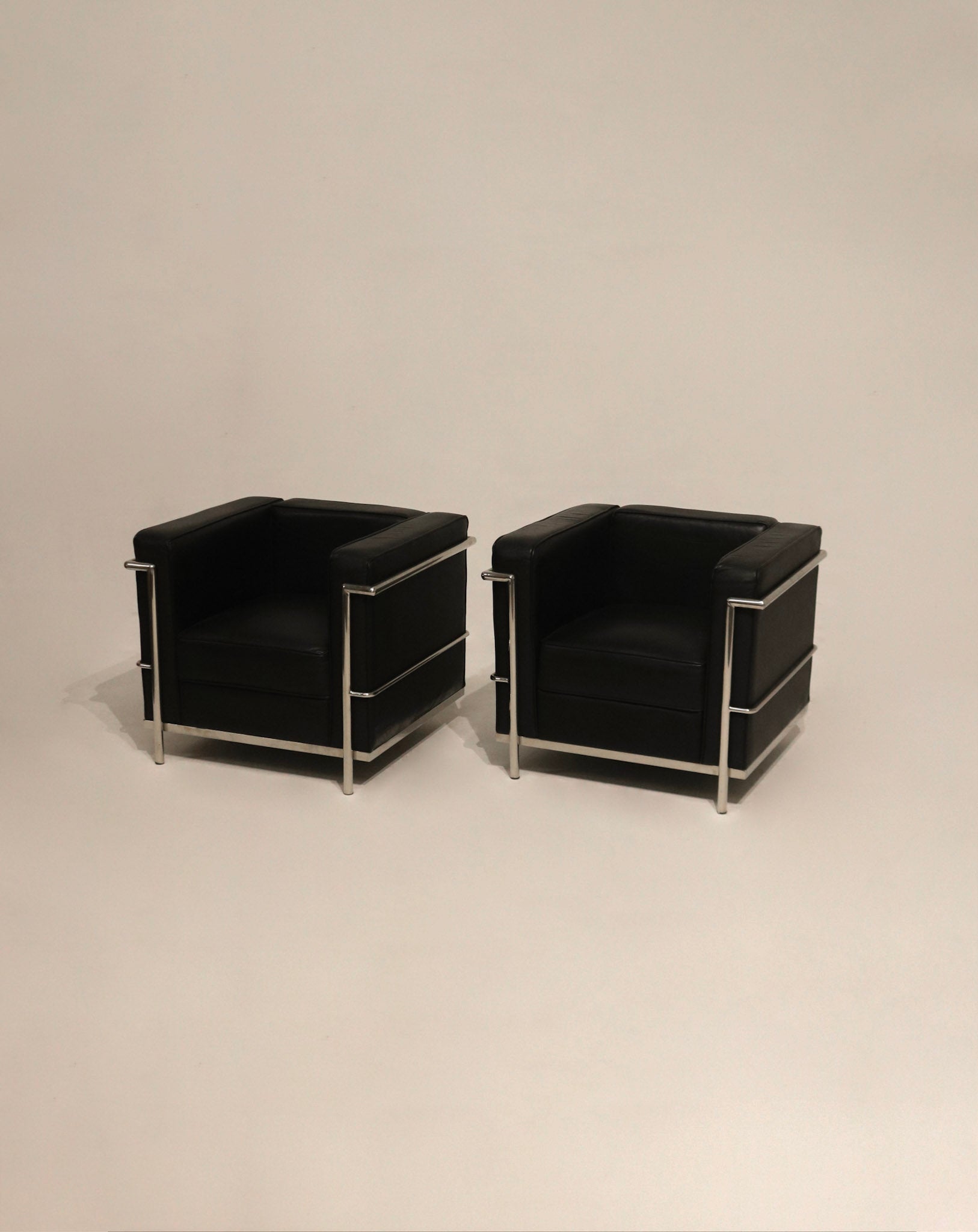 Hardware close-up on chrome base glides of LC2 chairs, pristine like-new condition