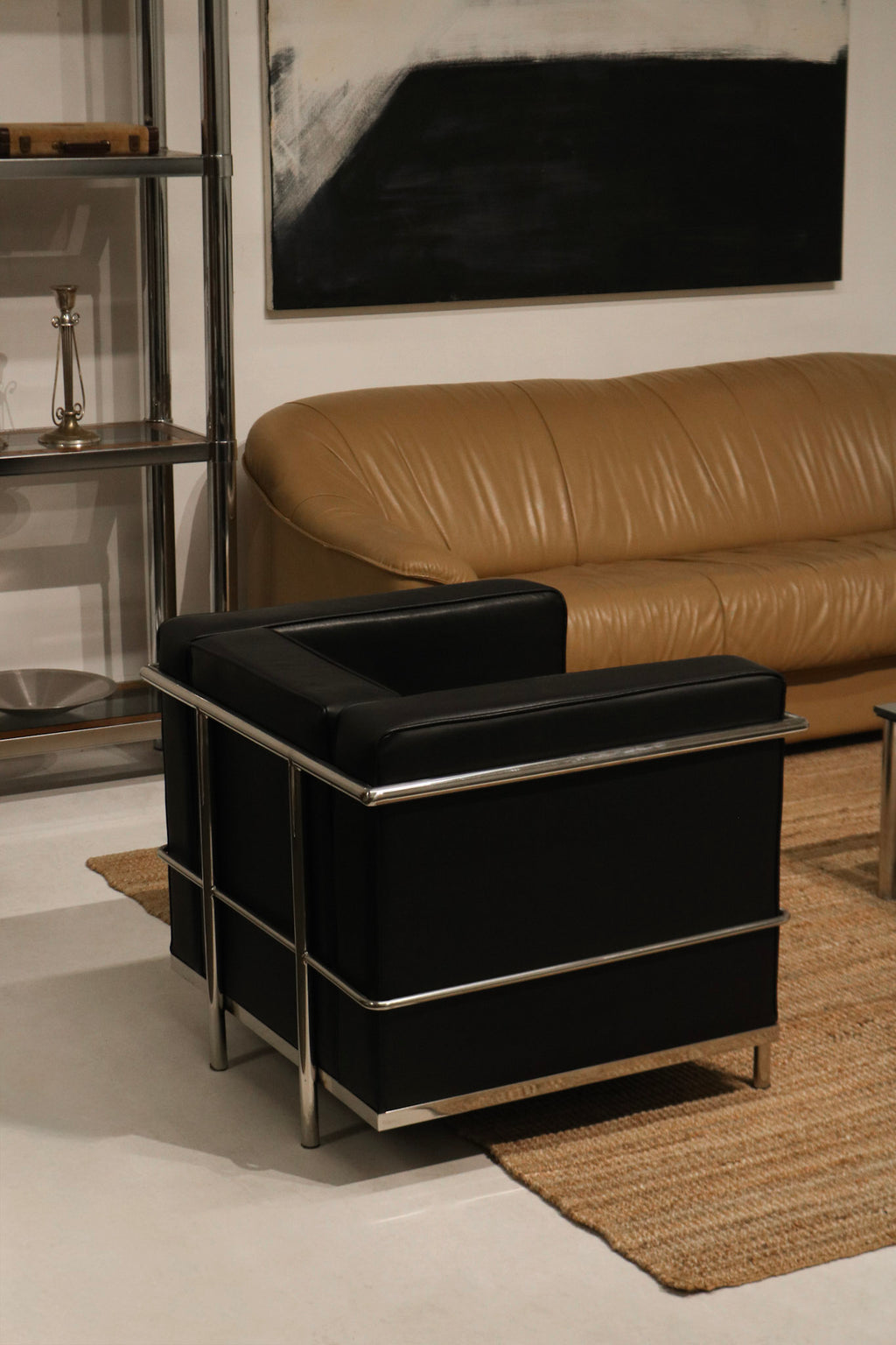 Close-up of chrome frame detailing on black faux leather LC2 Petit Modele armchair