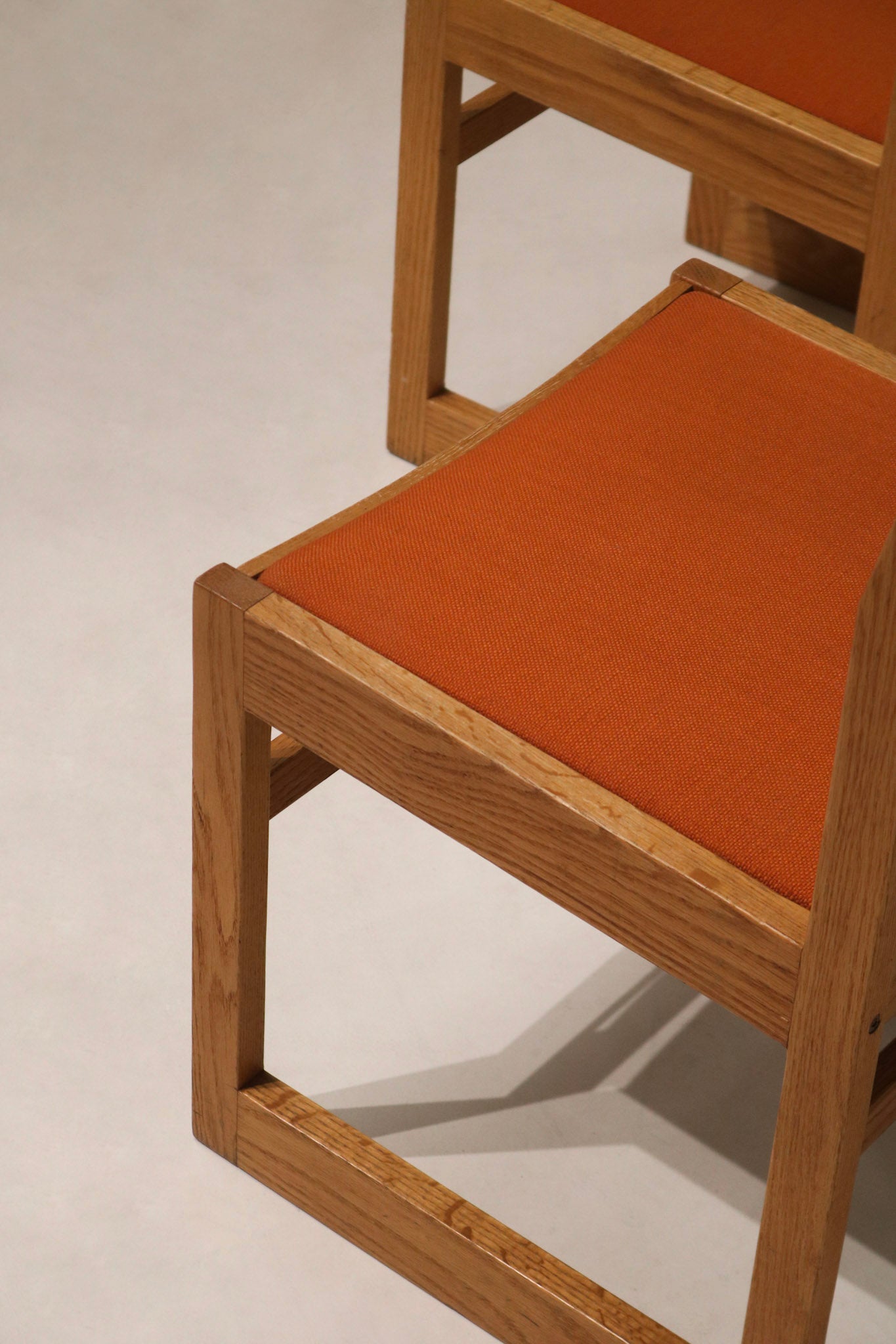 Close-up of orange tweed upholstery on Jasper chair seat showing woven texture, subtle patina and mid-century color fidelity.