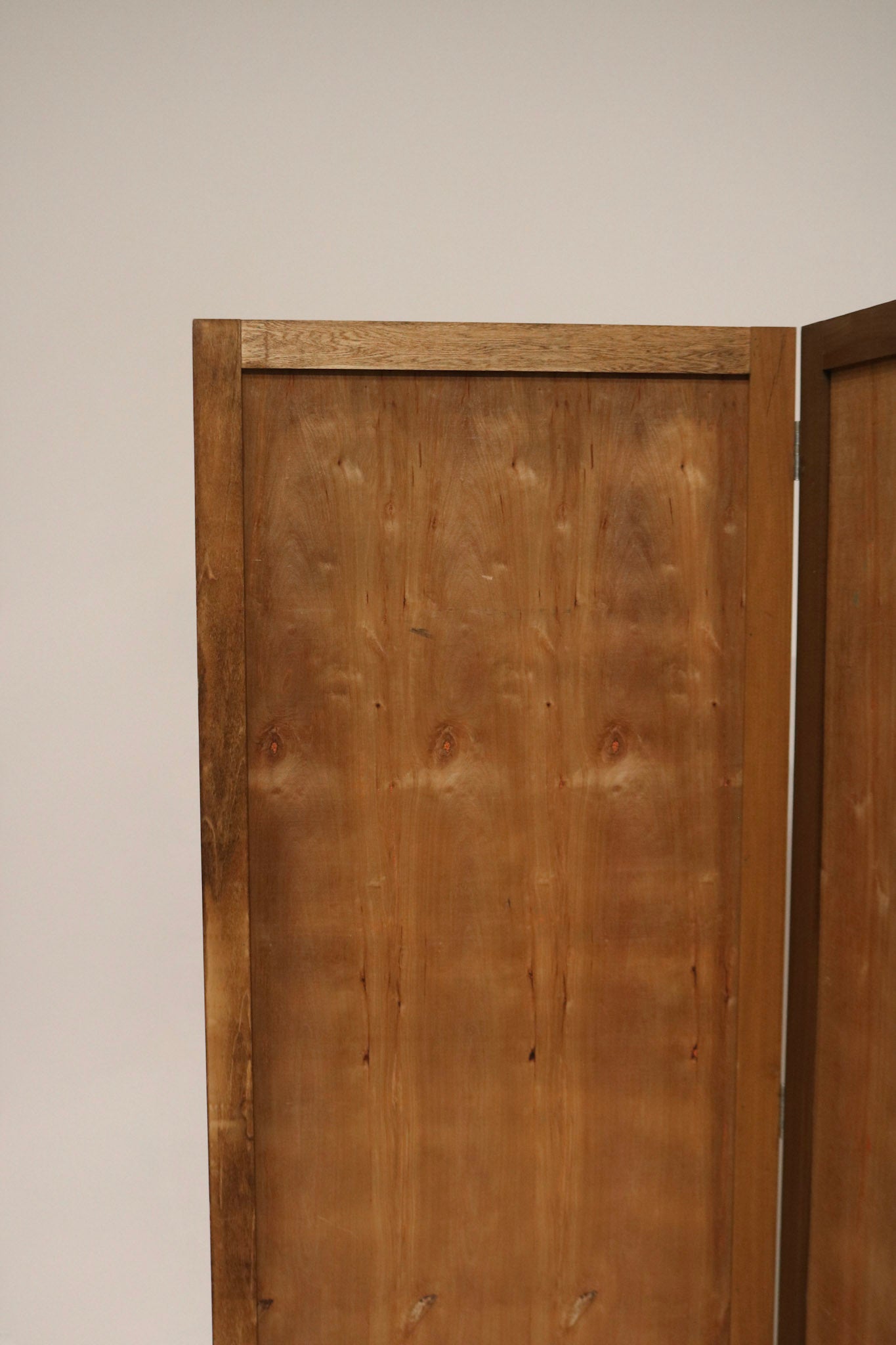 Styled shot of pine wood folding screen used as room divider with warm natural finish, complements eclectic NYC interiors.