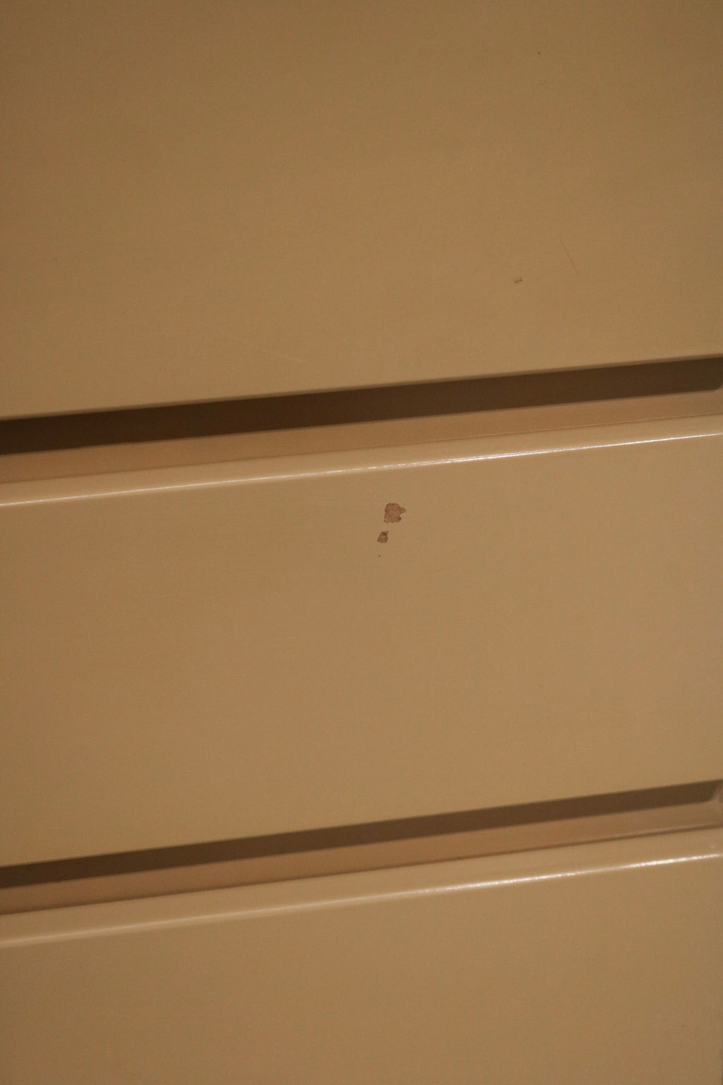 Detailed view of left side panel with subtle chips on the lacquered wood finish