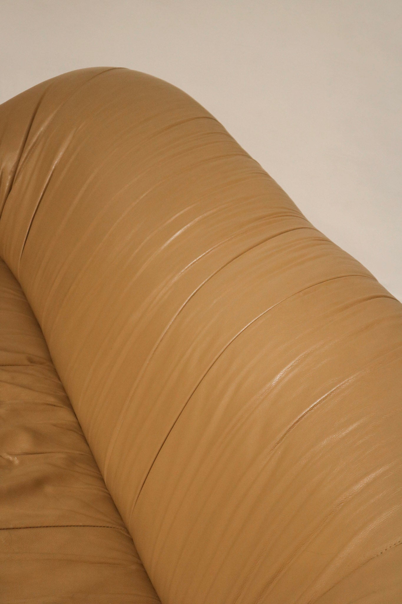 View of the sofa’s base and legs with beige brown leather finishing