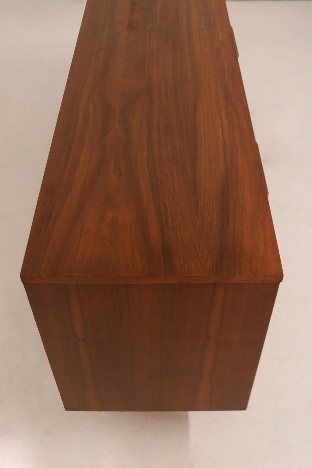 Close-up of walnut wood grain and vintage patina on top surface of MCM dresser