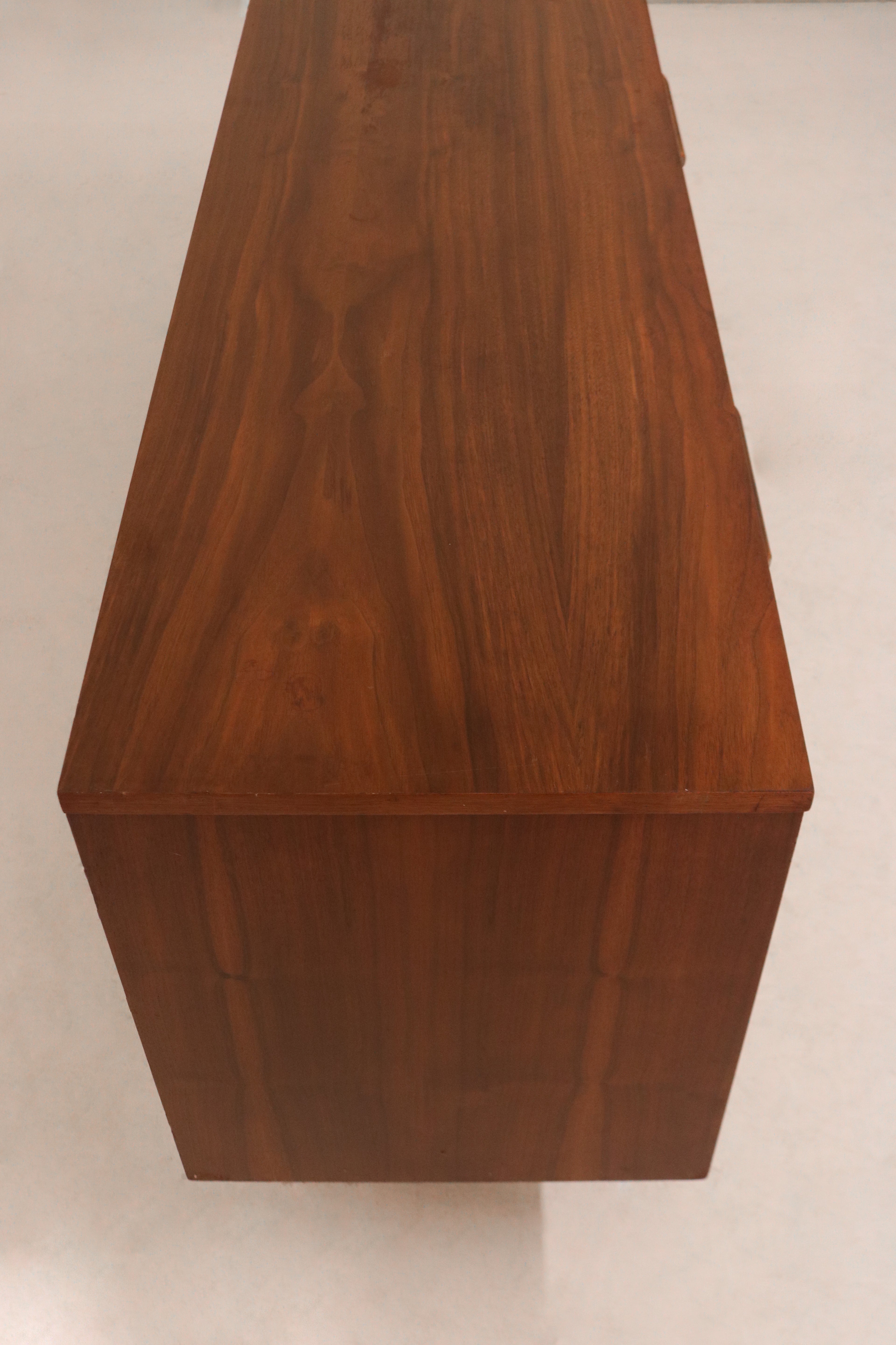 Close-up of walnut wood grain and vintage patina on top surface of MCM dresser