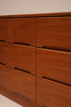 Detailed view of brass drawer pulls on the Danish MCM teak wood dresser