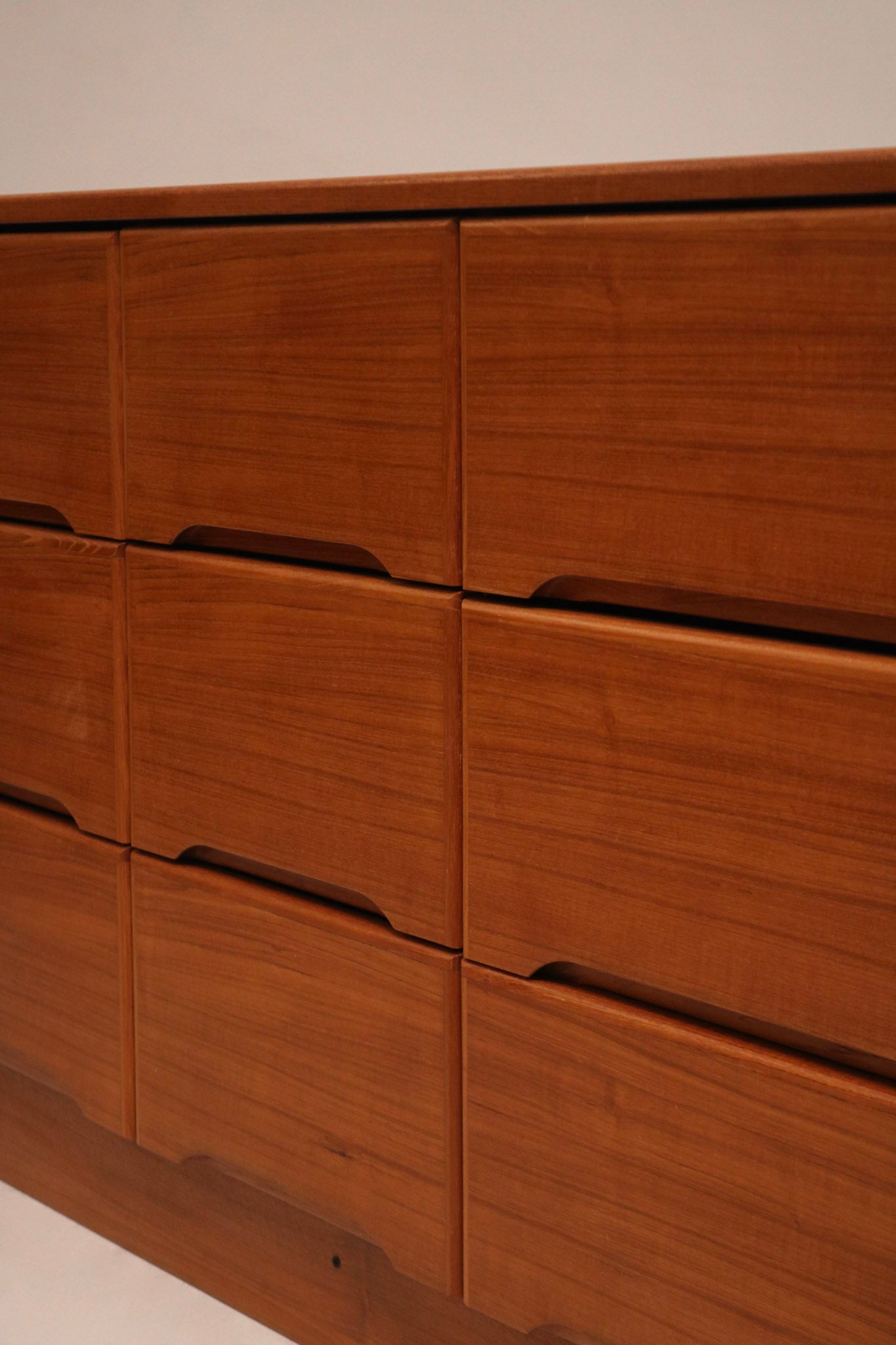 Detailed view of brass drawer pulls on the Danish MCM teak wood dresser