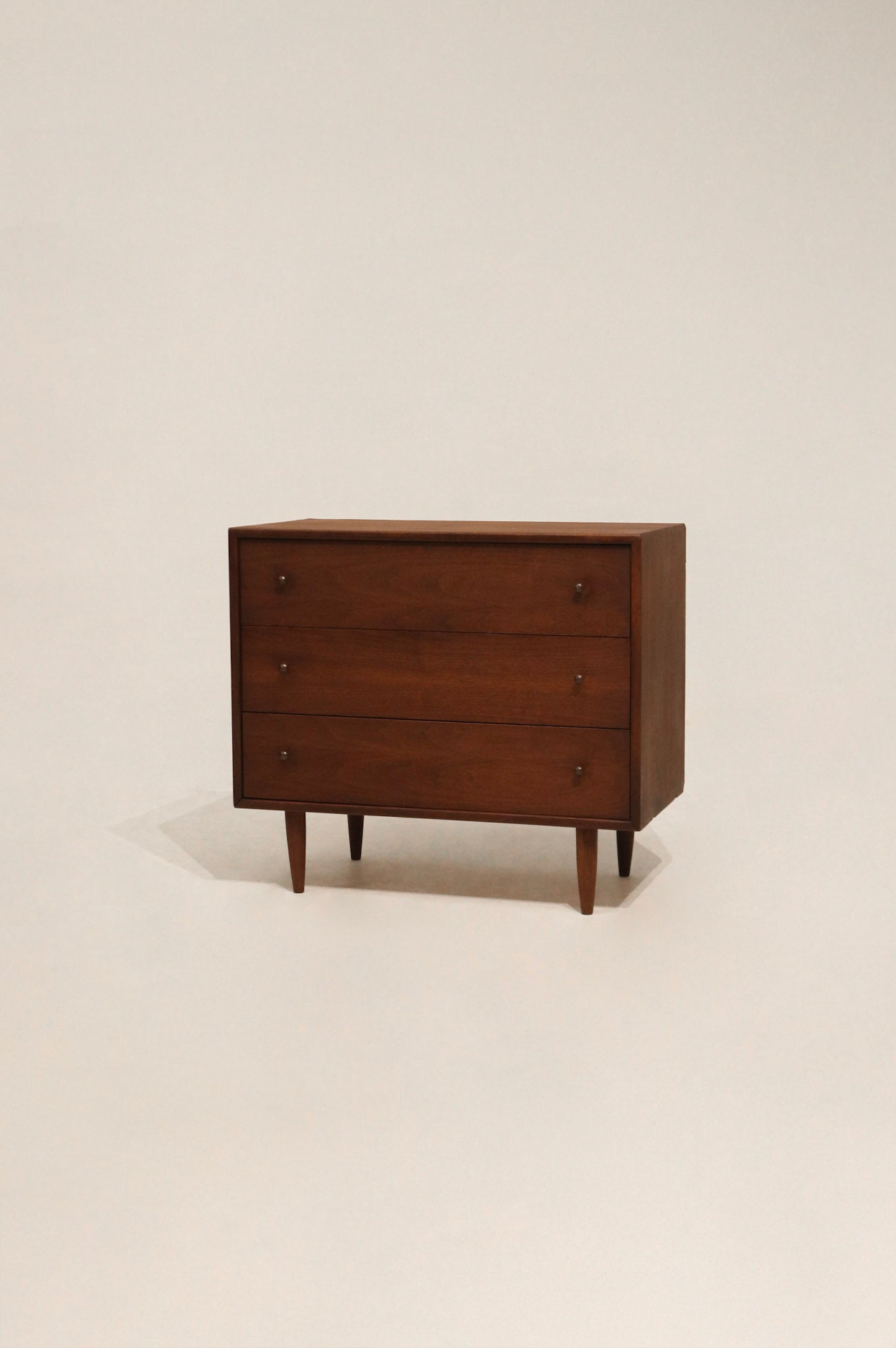 Full view of Mcm vintage small dresser made of walnut wood with sleek mid-century design