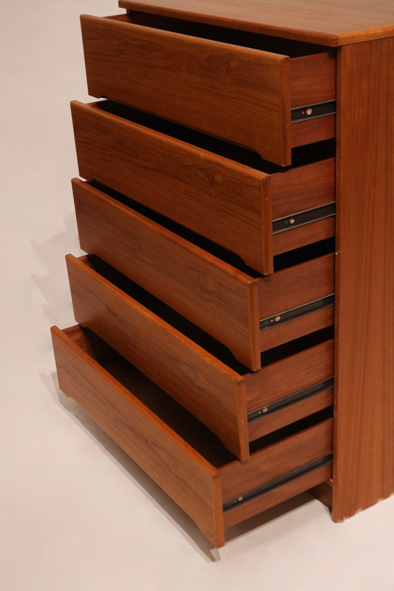 Zoom-in on dresser drawer handle detail in wood, showing minimalist MCM aesthetics