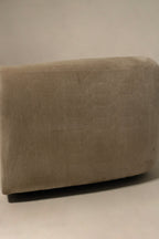 Armrest close-up of champagne velvet fabric, smooth velvet surface, gentle wear along edge, showing cushion support and upholstery finish
