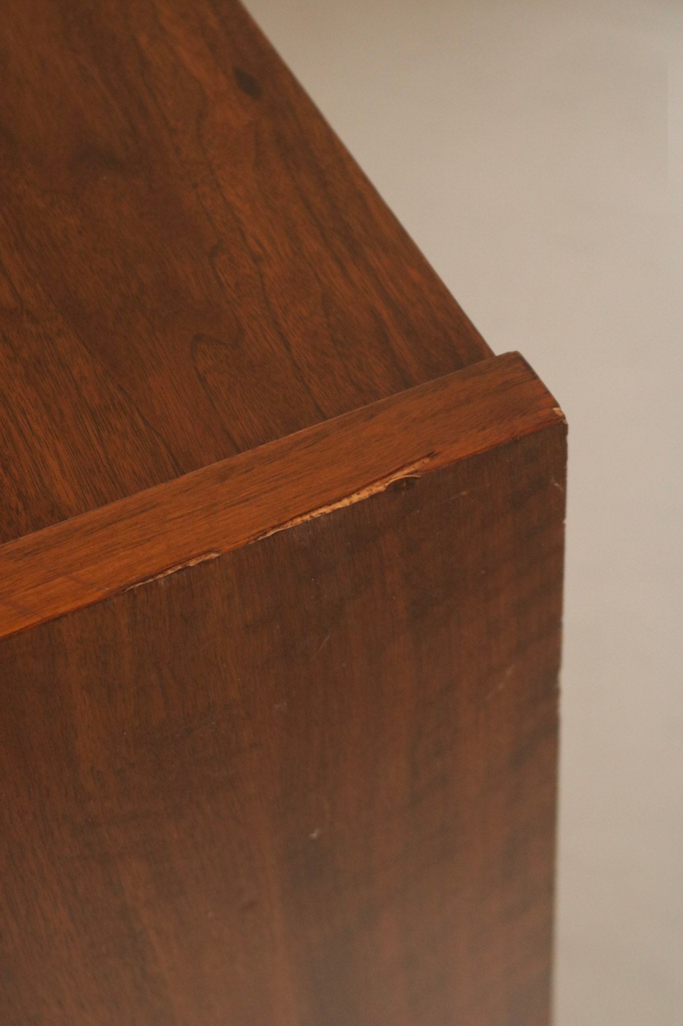 Texture close-up of walnut wood grain pattern, warm brown tones and mid-century finishing techniques visible on surface