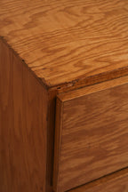 Textured look at dresser front showcasing wood grain patterns and drawer alignment