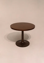 Full view of wooden round bistro dining table showing smooth wood finish and sturdy base