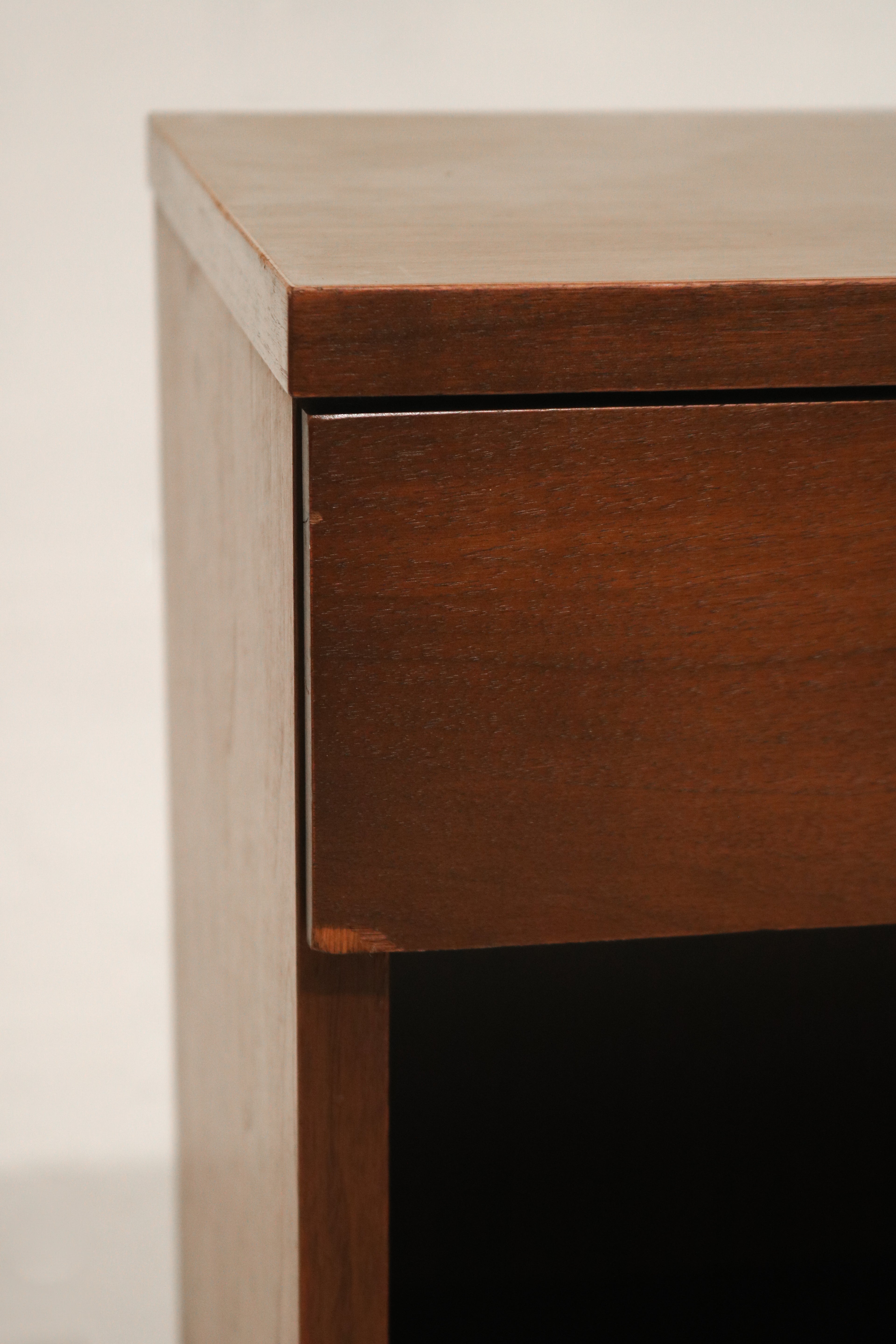 Detail of the drawer front showing smooth walnut finish and mid-century modern lines