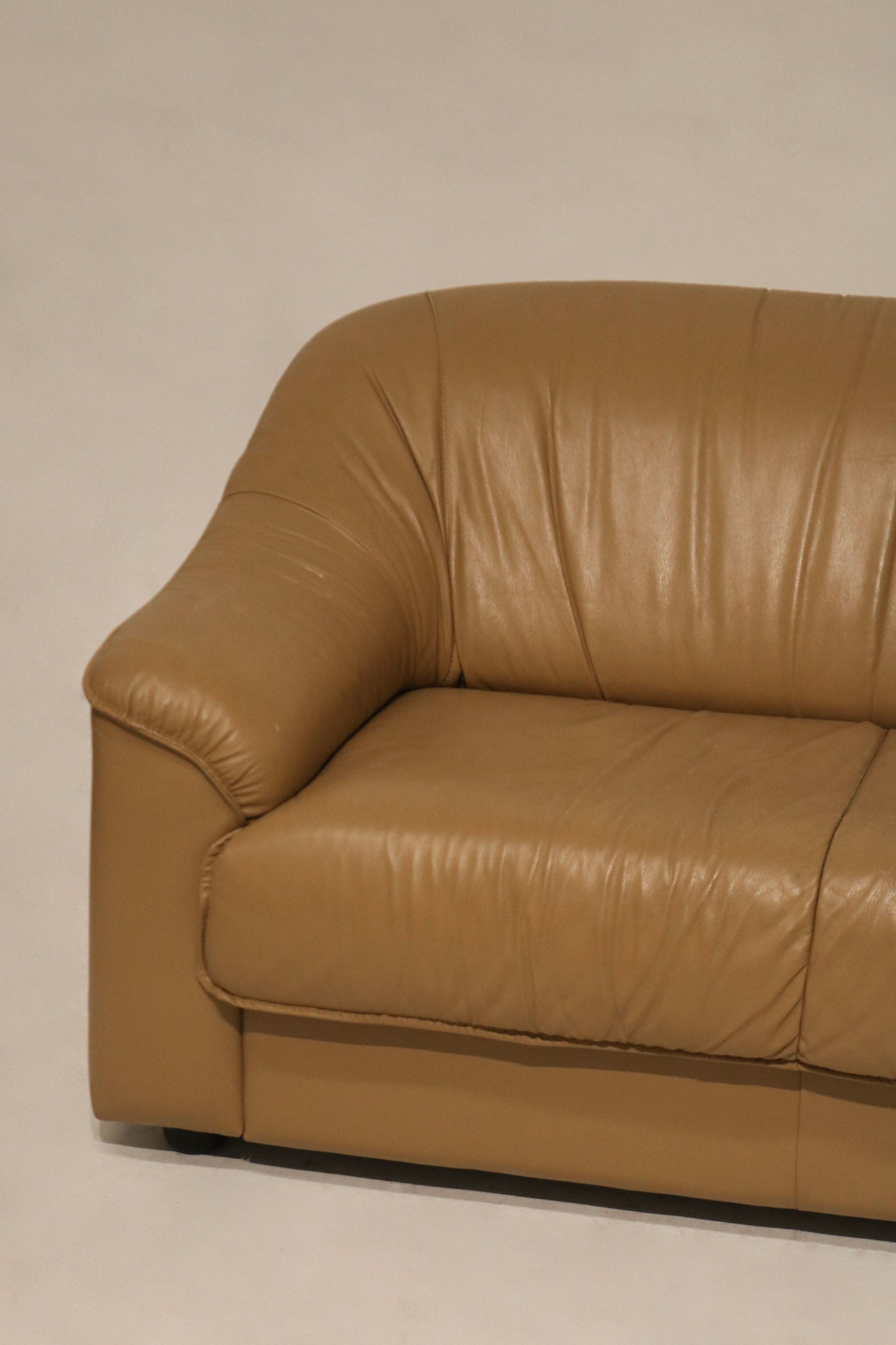 Angled corner view showing depth and structure of vintage Italian leather couch