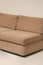 Arm profile close-up of fabric sofa couch showing rounded arm, fabric grain and edge stitching on vintage brown-pink upholstery