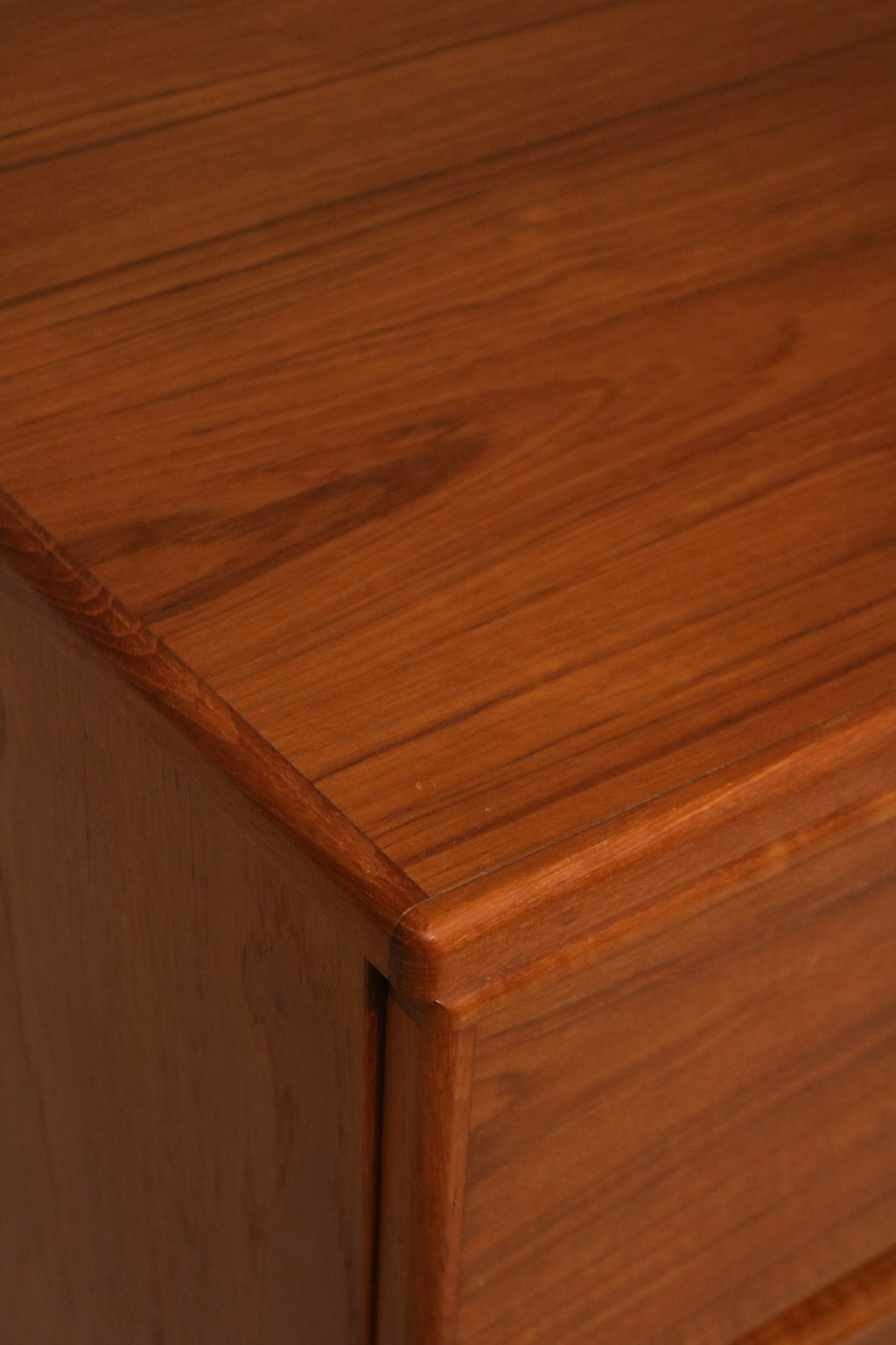 Angled view highlighting mid-century modern silhouette of Danish teak wood dresser