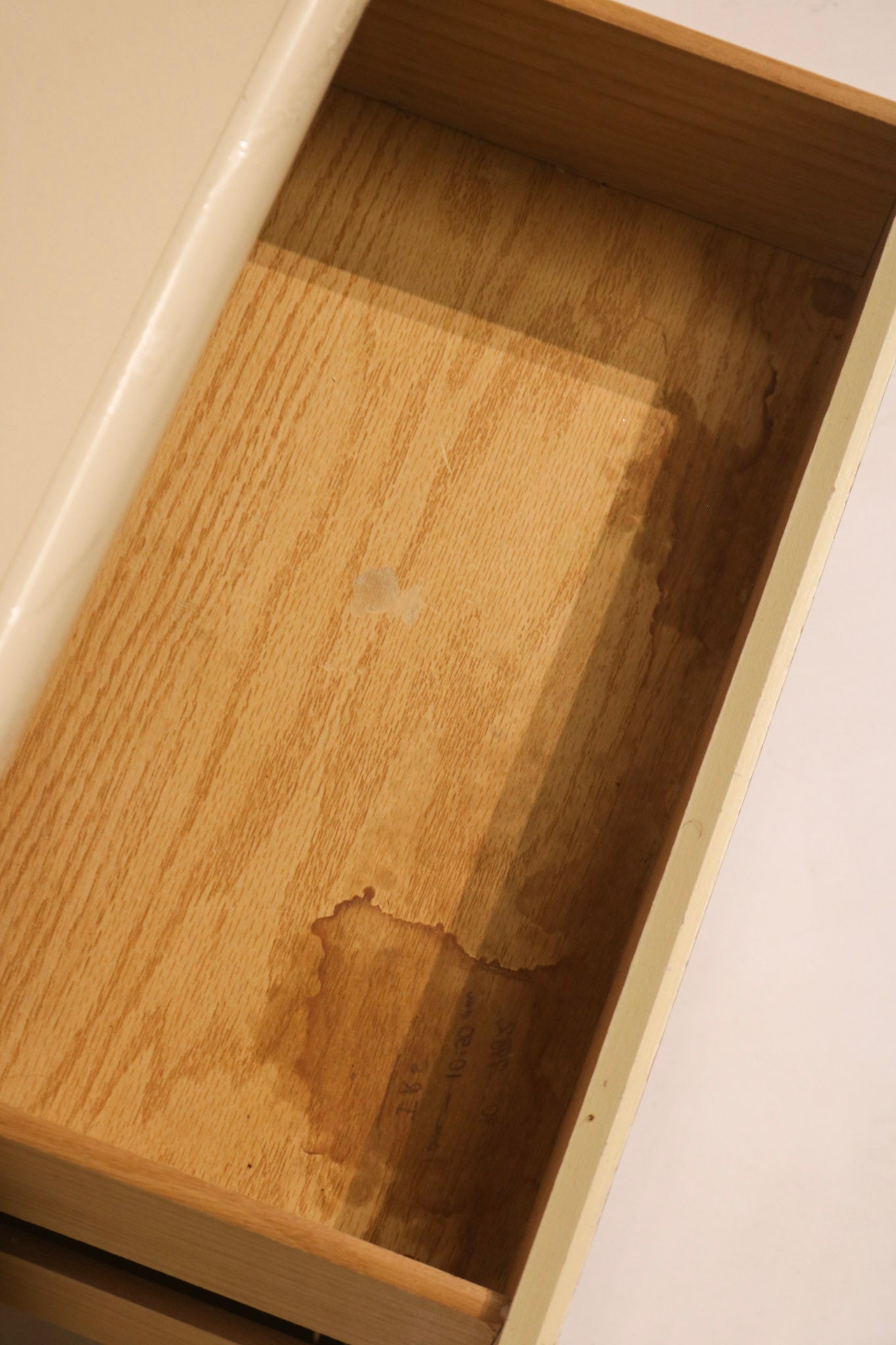 Interior view of drawer bottom showing signs of wear and stains