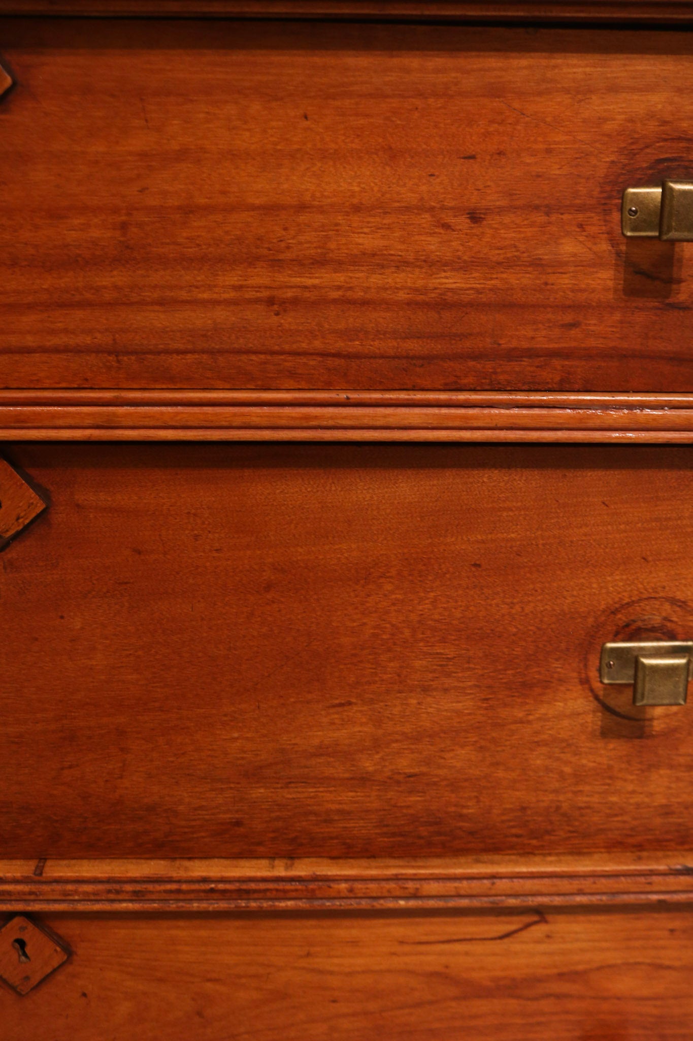 Close-up of drawer fronts featuring original keyholes and wood grain