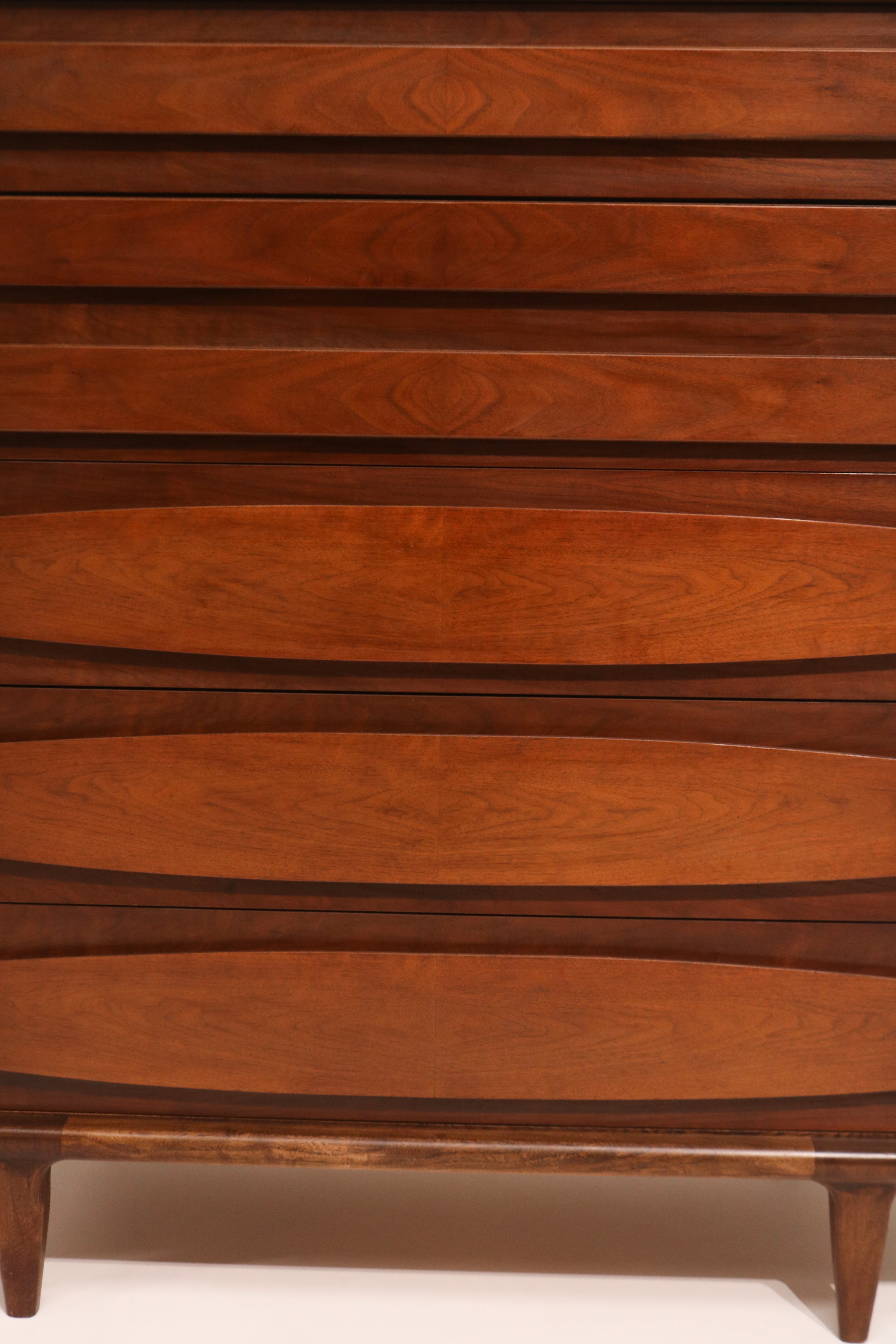 Close-up of drawer fronts with sculpted pulls highlighting walnut grain