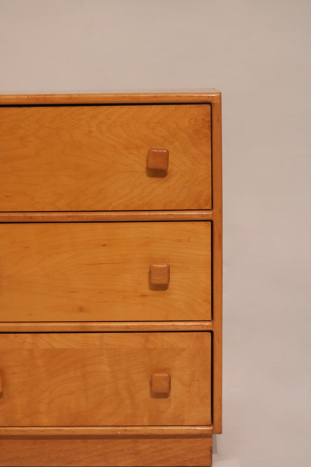 Close-up of drawer fronts featuring distinctive square wooden knobs