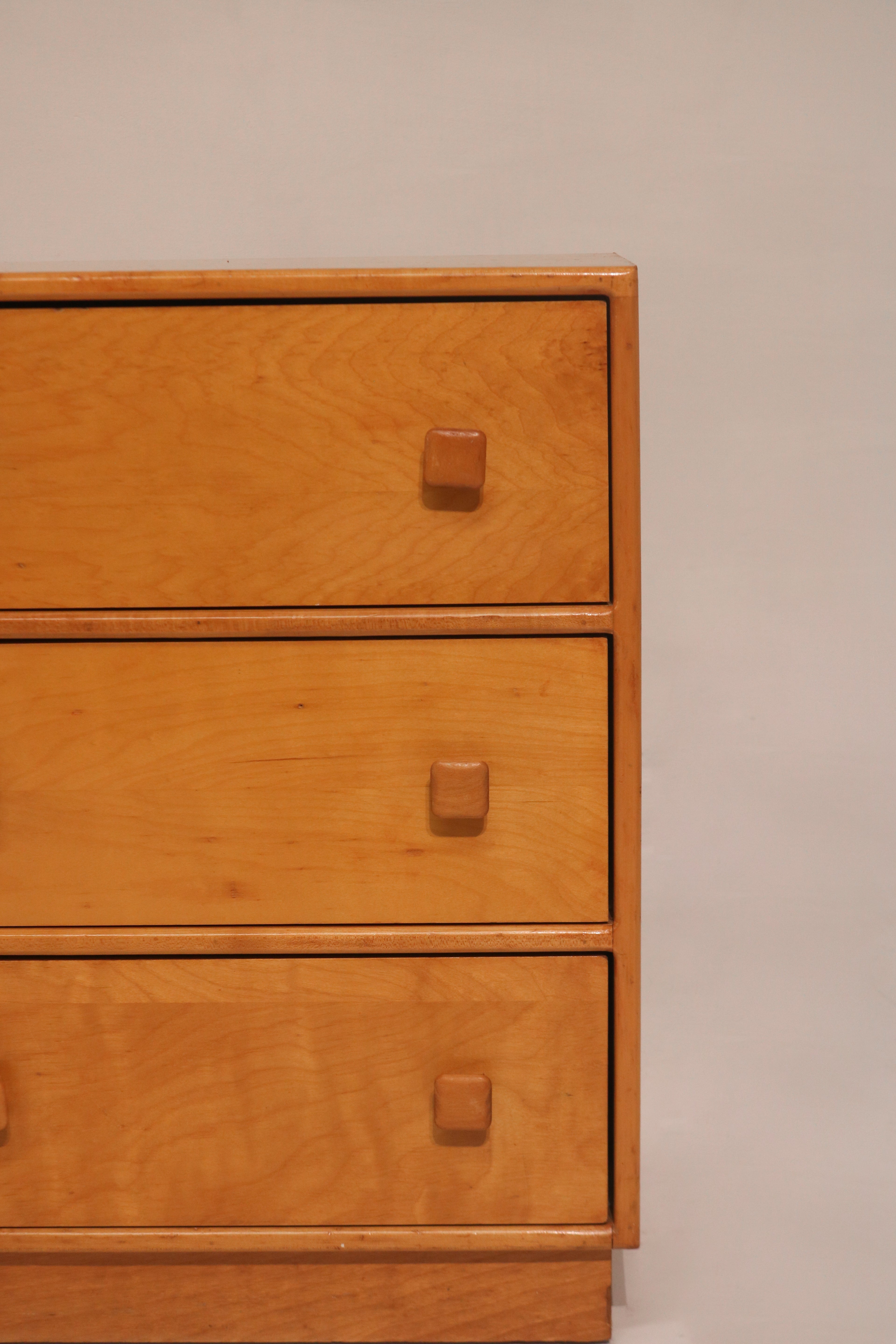 Close-up of drawer fronts featuring distinctive square wooden knobs