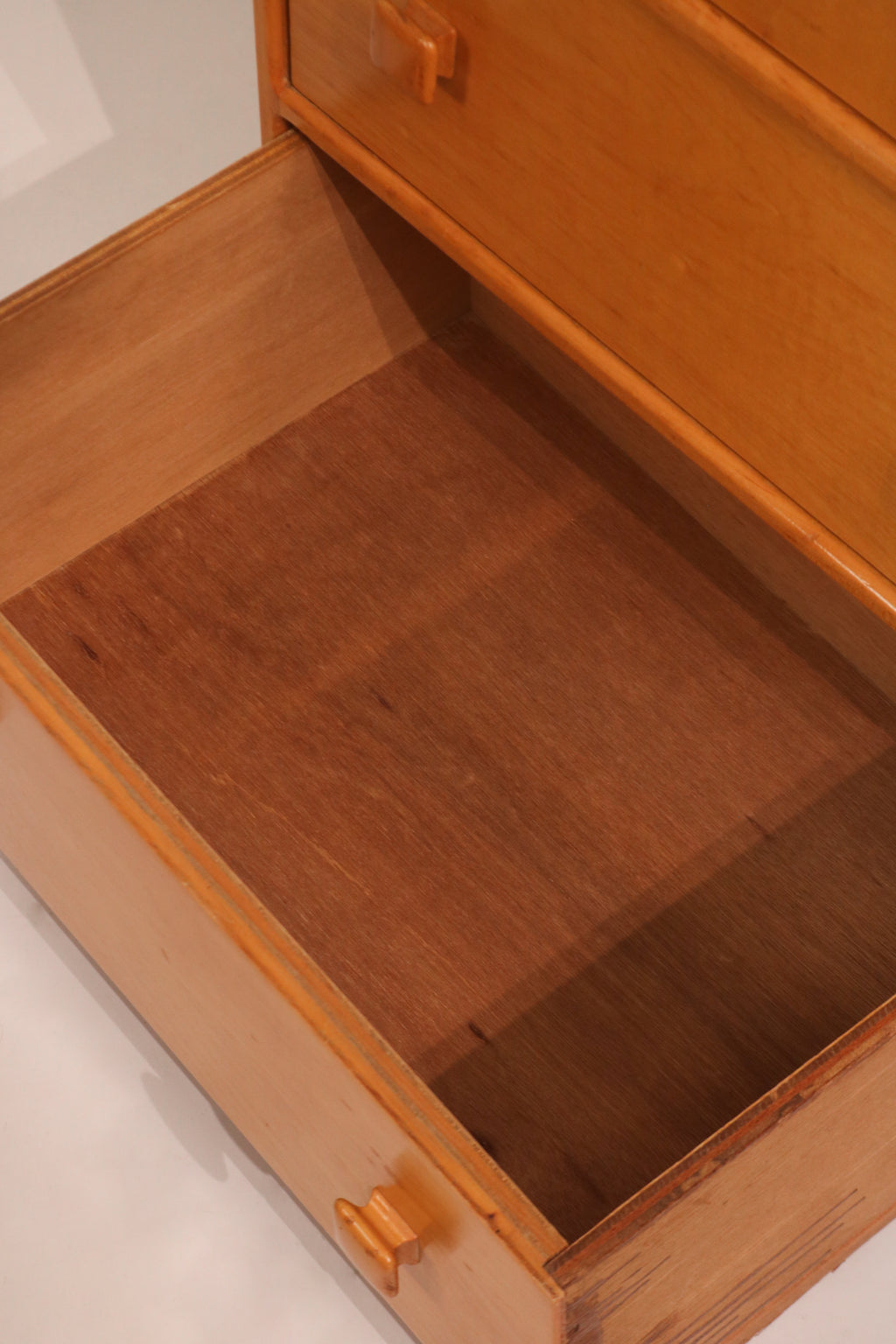 Interior view of drawer showing particle board construction and storage depth