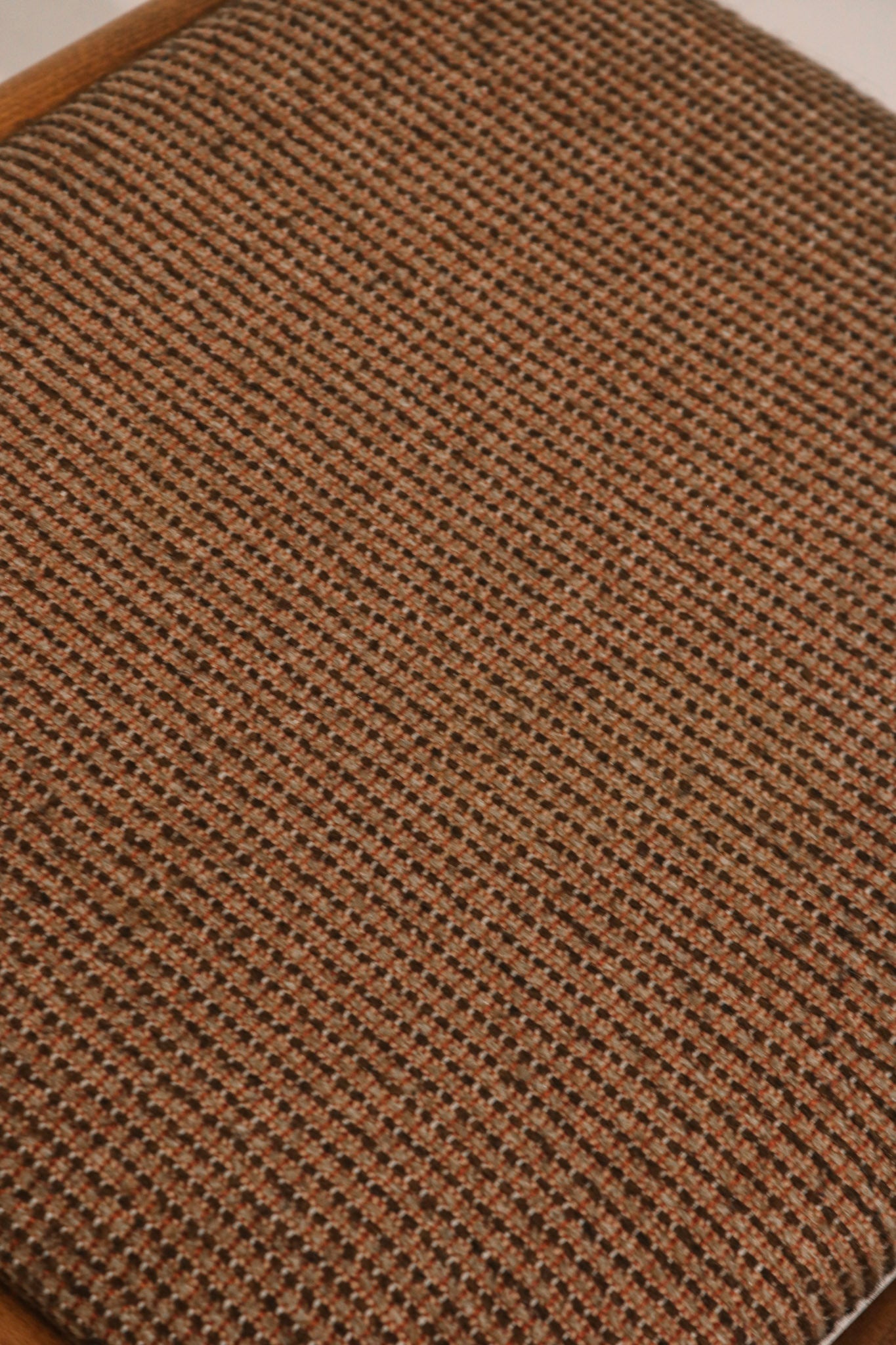 Close-up detail of brown woven fabric seat texture and condition
